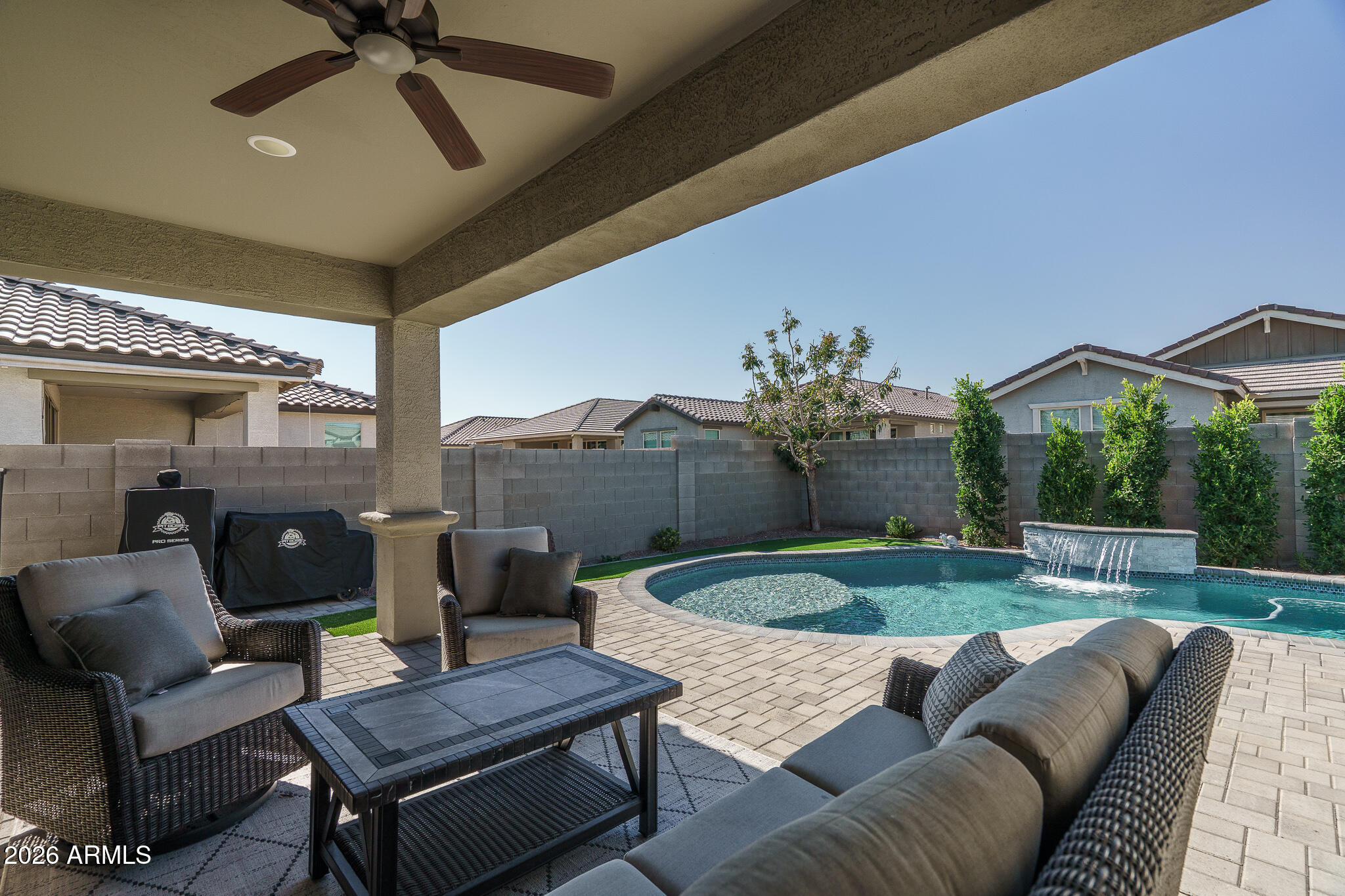 Beautifully maintained by its original owners, this thoughtfully upgraded home offers 3 bedrooms and 2.5 baths across 1808 SqFt with an inviting open great room layout. The gourmet kitchen showcases shaker-style cabinetry, granite counters, stainless appliances, a walk-in pantry, and a large island with breakfast bar and pendant lighting. Center-meet sliding glass doors open to a fantastic backyard featuring an extended paver patio, a sparkling pool with a water feature, and easy-care artificial turf ideal for kids and pets. One side yard is fully fenced, creating a perfect dog run. The primary suite includes an en-suite bath with an extended dual-sink vanity with makeup area, a separate tub and shower, and a spacious walk-in closet. Additional highlights include neutral two-tone paint throughout, plantation shutters in the bedrooms, a built-in workstation, and a 2-car garage with epoxy floors, overhead storage racks, built-in cabinets, and a convenient service door to the side yard.
