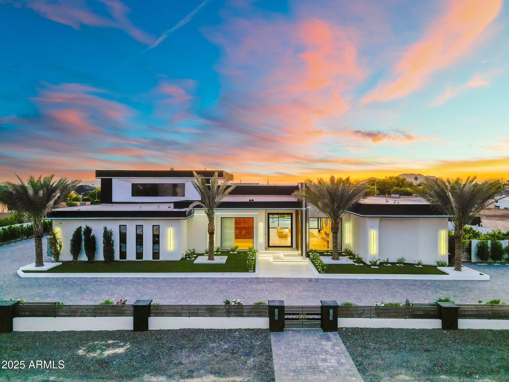 From the moment you arrive, sleek contemporary lines and a striking façade set the tone for the sophistication within. Inside, the open-concept layout is warm and welcoming, enhanced by rich wood accents, soaring ceilings, and an abundance of natural light.
The chef's kitchen is a culinary dream, outfitted with exquisite custom cabinetry, premium appliances, a generous island, and a statement hood above the professional-grade range. A hidden butler's pantry, tucked behind a secret cabinet door, offers seamless functionality for effortless entertaining.
Each bedroom is a private oasis, thoughtfully designed with expansive closets and en-suites showcasing exquisite designer finishes. The primary suite is an extraordinary haven of indulgence, boasting a lavish resort-style bath sanctuary with a state-of-the-art steam shower 
Ascend the grand staircase to discover a bespoke theater room and an elegantly appointed entertainment loungedesigned for both lavish hosting and private relaxation, offering an elevated lifestyle experience beyond compare.

Step into the backyard and experience true Arizona resort-style living. The expansive covered patio, outdoor fireplace, sparkling pool and spa, and lush landscaping create the ultimate private oasis. Whether enjoying a sunset swim or hosting under the stars, this outdoor space is unforgettable.
Car enthusiasts will love the nine-car garage, offering ample space for vehicles, ATVs, or boats.

Sports lovers will appreciate the private pickleball, basketball, volleyball and soccer court, ideal for active living and fun with guests.
The detached casita features hardwood flooring and upscale finishes, perfect for guests, a home office, or in-law suite.