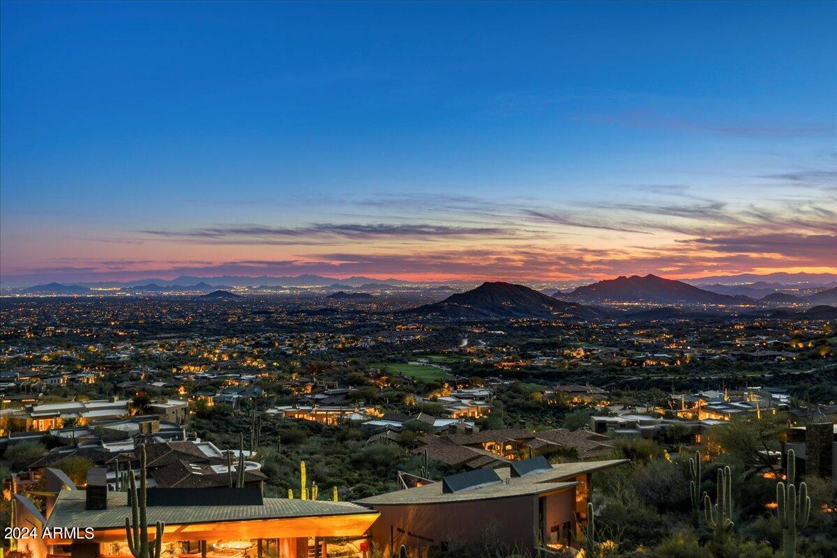 FIRST TIME ON THE MARKET! Step into one of the loftiest residences in North Scottsdale! This European Style Estate, envisioned by renowned architect Bing Hu and brought to life by Shiloh Homes, nestles into a private hillside with the National Forest as its expansive backyard. Experience the epitome of privacy and serene living on over 2 acres, crafted with steel and concrete, tucked away in the secluded village of Sunset Canyon. Marvel at the extraordinary, rare views that span from sunrise to sunset, capturing city lights and everything in between! The residence boasts a primary bedroom, three ensuite bedrooms with a private sitting area and bar, two offices, a home theater, two wine cellars, ten bathrooms, and a guest house with a separate entry. FULL GOLF MEMBERSHIP AVAILABLE. Welcome to a haven of luxury, views, and unparalleled craftsmanship! Custom finishes abound, including vaulted and beamed ceilings, seven fire places, and two charming fire pits. Step into an exquisite culinary dream kitchen with dual islands, three farm sinks, three dishwashers, and a spacious butler's pantry. The home also features both a staircase and a stunning elevator, providing access to every level of the house!