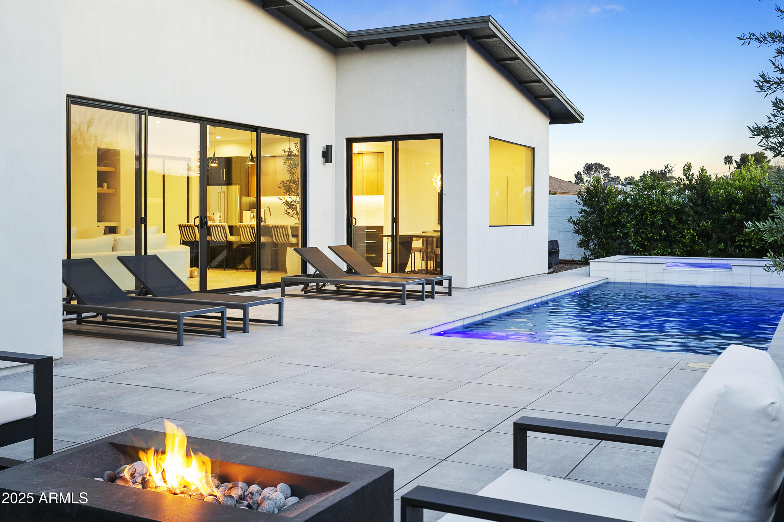 WOW  Welcome to a one-of-a-kind contemporary home in the heart of Arcadia Lite, a 2022 new build designed with clean lines, refined finishes perfect for modern living. Every inch of this custom residence reflects a commitment to quality craftsmanship and thoughtful design, offering the perfect blend of style, comfort, and energy efficiency. From the moment you arrive, you'll notice the home's striking modern aesthetic and meticulous attention to detail. Built with energy efficiency in mind, the home features spray foam insulation in both the walls and roof deck, Low E Milgard windows, and two high-performance TRANE HVAC systems for optimal climate control. The garage includes an insulated door, app-controlled opener,