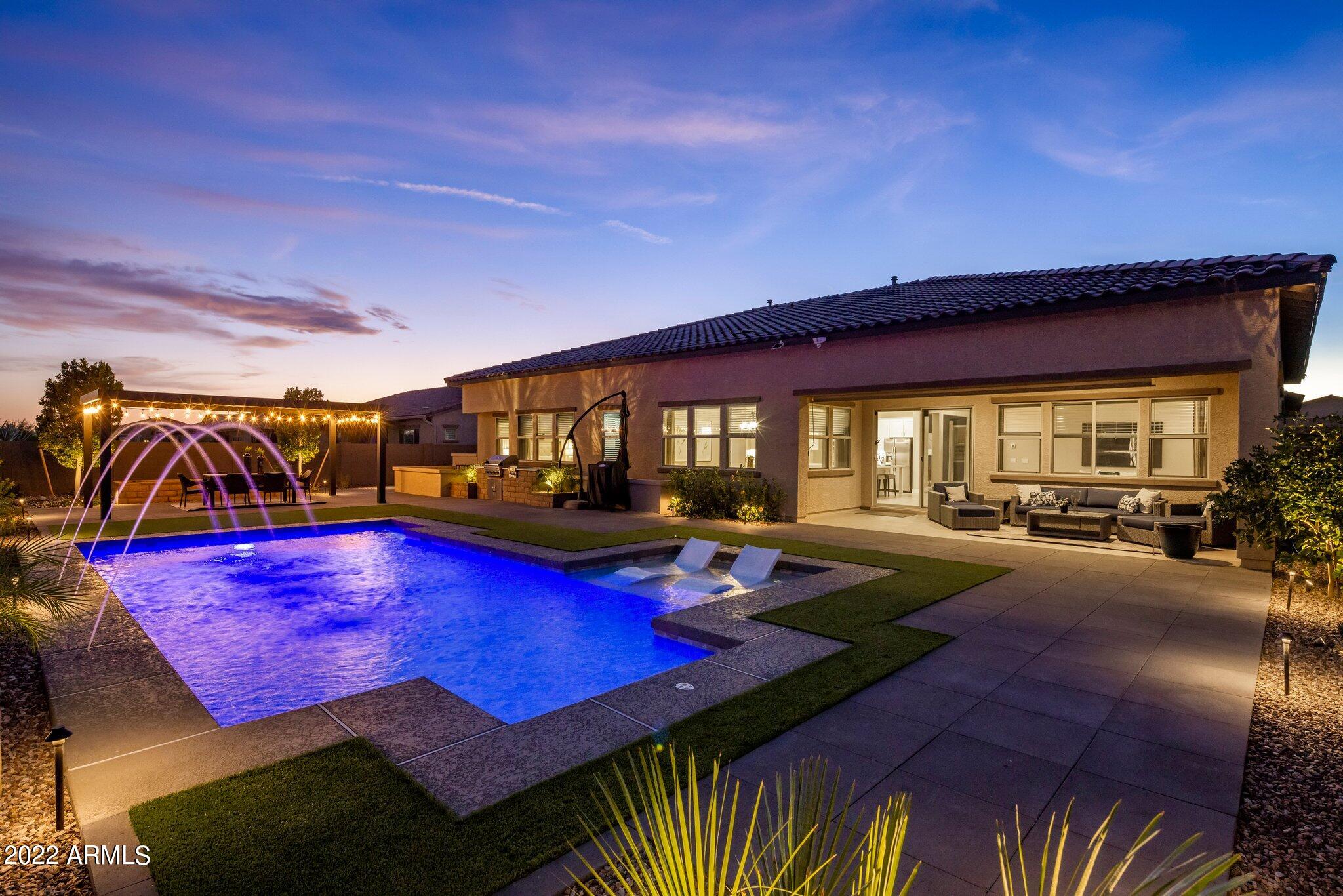 Exquisite NextGen single story luxury home offers a spacious 4,369 sq ft open concept floor plan featuring 5 bedroom suites, home office, 4.5 bathrooms, along with a resort style backyard pool oasis, 4-car garage, RV gate w/extend parking pad, distant mountain views, and an oversized lot backing to the New River desert wash in the prestigious gated north Peoria Deseo community. This impressive home welcomes you with a portico and private courtyard designed to accommodate a cozy sitting area with shade sails for relaxing and enjoying our beautiful Arizona weather. Once inside, appreciate the grand entrance into a great room and formal dining area displaying designer touches throughout, neutral color palette, luxury wood-like plank flooring in all the right places, and a wonderful executive gourmet kitchen equipped with high end SS appliances, stylish quartz countertops w/complementary colored glass tile backsplash, timeless bright white cabinets w/crown molding, upgraded lighting fixtures, a large walk-in pantry, butler's corner, sizable center island w/undermount sink and breakfast bar open to a dining nook and great room. From here, you have great access to the resort-style backyard via an arcadia glass slider, capturing the essence of indoor/outdoor living. Step out to the extended covered patio and explore this tranquil space and imagine enjoying the refreshing pool with large Baja shelf, gorgeous Sonoran desert views, fantastic pergola creating a space for dining alfresco, extended oversize pavers providing for ample seating arrangements, an essential built-in BBQ w/side burners and outlets, and a wonderful solar roller shade adding comfort to patio seating. Back inside, wander over to the Owner's retreat offering a relaxing sitting alcove surrounded by a wall of windows immersing the room in natural light, along with a spa-like ensuite bathroom displaying separate vanities w/integrated dual sinks, custom tiled walk-in shower separate from deep soaking garden tub, private toilet, and a massive walk-in closet w/customized organization system. The other four bedrooms are designed with ensuite bathrooms and walk-in closets, with one of the bedrooms boasting its own living/bonus room and separate entrance. The home office and oversized laundry room round out this incredible floor plan, so be sure to take a look. Close to hiking and biking paths, top rated schools, popular restaurants, convenient shopping, and distant mountain views add to this home's unique qualities, making it the perfect place to call home!