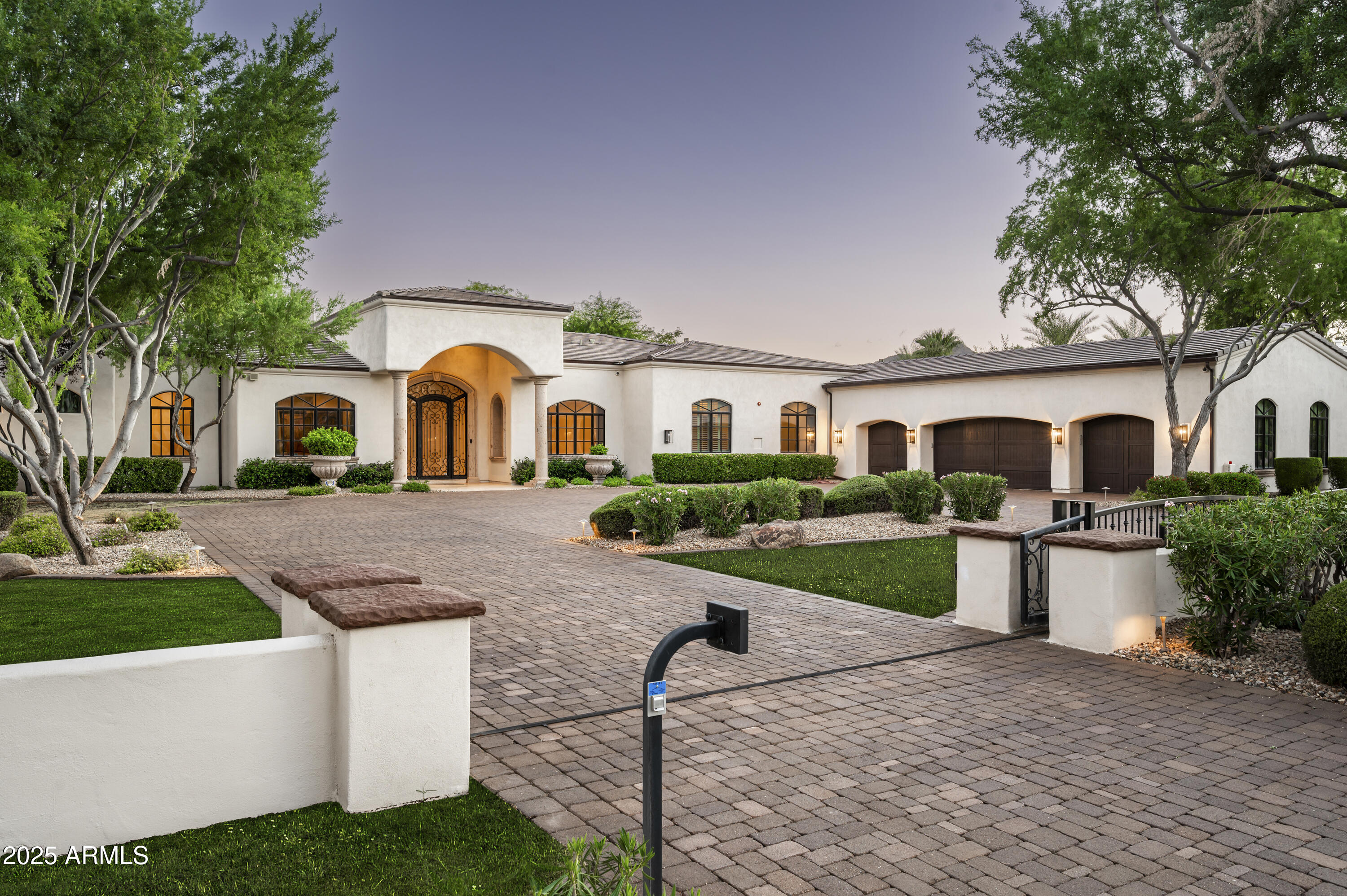 Luxury, Location & Livability in Paradise Valley. Located in the highly sought-after 3 C's school district, this beautiful gated 7,018 sqft home sits on a lush quiet acre + offers 5 bedrooms, 7 baths, a game rm, gym, 800 bottle wine rm, 4 car garages + a lift for a 5th car. Inside, refined living spaces feature soaring ceilings as high as 18 ft and an automatic glass pocket door to the outside . The chef's kitchen is equipped with Wolf, Sub-Zero, and Cove appliances, a large island, dual pantries + a bar w/ fridge, sink + new ice maker. The primary suite has 2 generous closets, dual water closets and a steam shower. A resort-style backyard includes  pool w/ baja shelf, outdoor barbecue + fireplace, Sport Court, putting green+ large grass area. Recently updated with a new roof, 4 new variable-speed HVACs, 2 tankless water heaters and it was also painted outside and inside with  new lighting fixtures on the exterior. This home is turnkey, luxurious, and perfectly positioned near world-class dining, golf, and shopping.