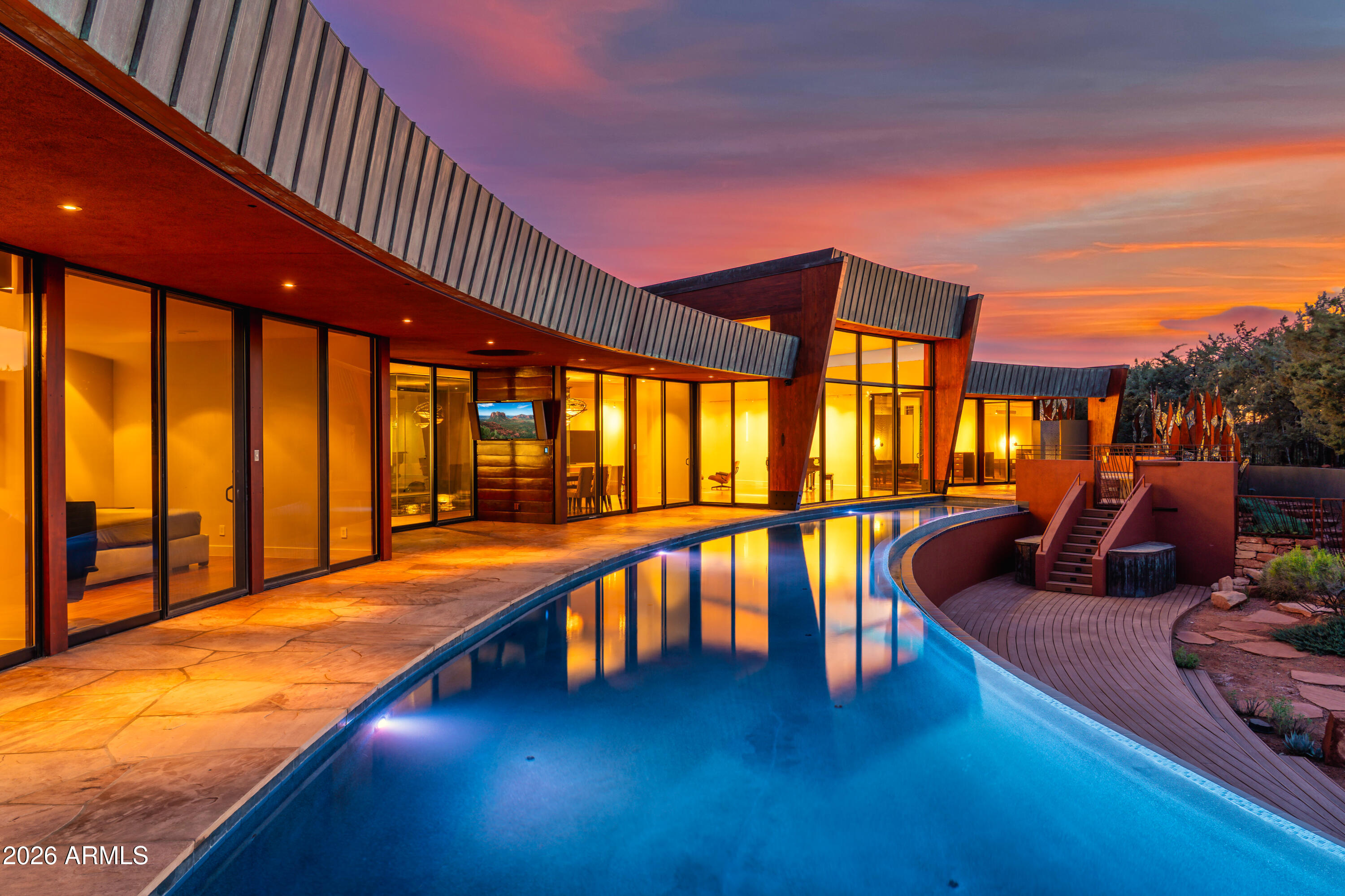 When you ask to see the best in modern architecture with views in Sedona, this is truly one of the crown jewels. Some homes transcend architecture and become part of Sedona's cultural and design legacy. The striking modern residence known as Cielo Vista Estate (Sky View Estate), overlooking Boynton Canyon, is one of those rare properties. Designed and built by renowned architect Aldo Andreoli, the home is instantly recognizable for its sweeping curved form, sculptural presence, and profound connection to the surrounding red rock landscape. From nearly every room, expansive walls of glass frame uninterrupted views. Water is a defining architectural element throughout the property, both indoors and out. An 80 foot curved pool and dramatic indoor water feature bringing Feng Shui balance. During construction, as the pools filled, the architect realized the reflection of the home itself completed the design. The water became not simply an accent, but an essential architectural component, adding a vertical dimension that enhances the home's presence.

At the heart of the residence is a newly remodeled interior water feature enclosed by four walls of floor to ceiling glass. From the kitchen, dining, and living areas, one can sit comfortably indoors while watching snow gently fall into the water during winter months, creating a rare and magical experience that blurs the boundary between interior and exterior living.

Inside, Cielo Vista Estate challenges the misconception that modern design must feel cold. Drawing from his Italian heritage and experience designing lofts in New York, Andreoli infused warmth through thoughtful material selection, color, texture, and proportion. The home unfolds as an open, loft-inspired environment anchored by a dramatic atrium. Italian influences are evident throughout, including custom doors crafted in Italy, mosaic tile accents, and architectural details that balance refinement with livability.

Once owned by the beloved Mary D. Fisher, the home carries a legacy of vision, creativity, and appreciation for meaningful design. The name Cielo Vista Estate reflects both the home's elevated position and Sedona's iconic red rock landscape. Romantic yet grounded, bold yet serene, the residence captures the emotional essence of Sedona itself.

Properties of this architectural significance, provenance, and setting rarely come to market.

FEATURES AND IMPROVEMENTS
-- 5 BD; 4.5 BA; Huge Storage Basements Newly Painted with Fresh Coated Epoxy Floors; 6+ Cars Fit In Heated/Cooled Garages; Home Movie Theater; Game Room with Pool Table; Meditation/Yoga Room; An Office off Garage
-- New Plumbing
-- New Electrical
-- Newly Retiled Pool, Jacuzzi, and Outdoor Shower
-- New Jacuzzi Cover (On Order)
-- Freshly Resealed Flagstone Interior and Exterior
-- Whole House RTI Media System
-- Prewired for Power Blinds (Wiring in Place and Capped)
-- Night Lighting Option on Overhead Lighting, Including Garage
-- Champagne Tub in Primary Bath
-- Newly Remodeled Interior Water Feature with Floor-to-Ceiling Glass Enclosure
-- 80 Foot Curved Pool with Reflective Architectural Design
-- Direct Boynton Canyon Red Rock Views
-- Designed by Renowned Architect Aldo Andreoli
-- Custom Italian Doors and Mosaic Tile Accents
-- Dramatic Atrium and Loft-Inspired Open Living Design
-- New Kitchen Featuring Asko Dishwasher and Gaggenau Steam Ovens and Gas Range
-- Split HVAC Unit in Garage for Heating and Cooling
-- Additional Office Space Located Off Garage
-- Sprinter Van Height Garage Doors
-- Custom Blue and White Garage Cabinetry
-- Interior Paint Completed 3/2026 with Custom Designer Colors
-- Downstairs Mechanical Rooms Upgraded with New Epoxy Flooring and Paint

SIGNIFICANT IMPROVEMENTS
-- New Roof Installation Including All New Copper Fascia Scheduled 4/2026-5/2026
-- New Interior and Exterior Paint and Stucco
-- New Kitchen
-- Atrium with Water Feature Completely Remodeled
-- Exterior Paint & Stucco
-- Interior Paint

Strictly limited to qualified buyers and require a minimum of 24 hours notice to show property.