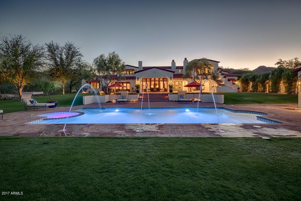 Vacant and Easy to Show. A beautiful gated entry and tree-lined circular drive lead to this glamorous Spanish Revival that will take your breath away. Situated on three and a half acres in the heart of Paradise Valley, this exquisite property offers six en suite bedrooms, seven bathrooms, garage parking for ten cars and nearly ten thousand square feet of luxurious living. Whether engaging in informal family breakfasts or elegant dinner parties, the chef's kitchen serves as a spectacular focal point to this flawless home. The master retreat is high-end living at its finest with exposed wood beams and a gorgeous fireplace adding refined elegance to the dream worthy hideaway, and the dedicated office has magnificent views from every vantage point. Multiple indoor and outdoor living spaces offer the perfect backdrop for intimate gatherings and the sophistication required for large-scale entertaining, and the incomparable design is intentionally comfortable, yet naturally elegant. The numerous sports amenities will definitely get your heart going with a putting green, bocce court, pool, spa, and huge grassy play field perfect for an impromptu football game. Meandering walkways, fabulous patios and breathtaking mountain views create impeccable ambience and a resort-like setting that is nothing shy of perfection. One stroll through this tasteful residence and it's simple to see why it's been featured in Phoenix Home and Garden!