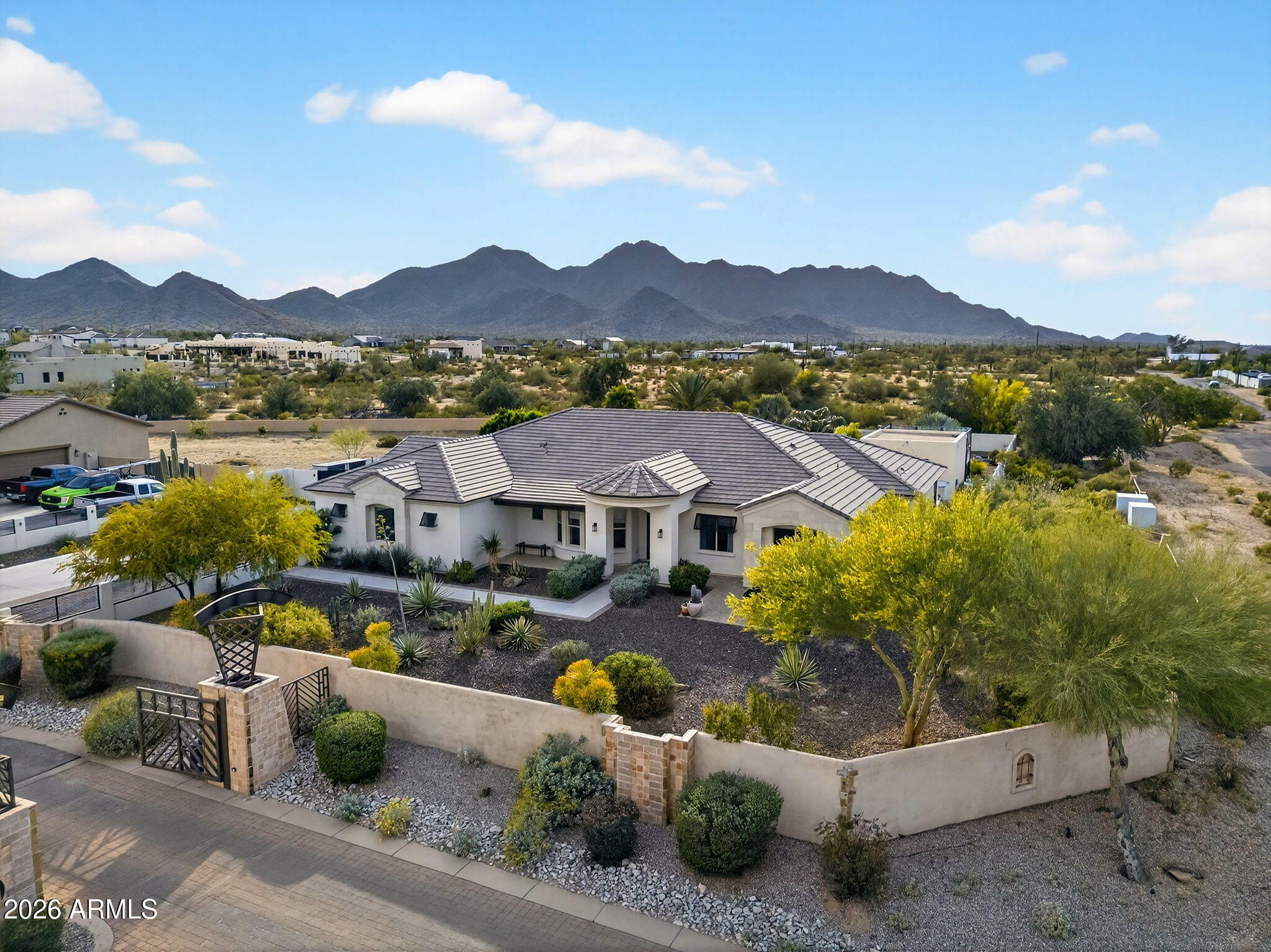Located in the exclusive gated community of Encanto Paseo and set on an expansive 1.33-acre lot, this property offers exceptional privacy, breathtaking San Tan Mountain views, sparkling city light views, and the peaceful beauty of the surrounding desert landscape, all framed by the dramatic backdrop of San Tan Regional Park.
The spacious great room floor plan is designed to capture the incredible views & provide seamless everyday living. The gourmet kitchen features top-of-the-line stainless steel appliances, marble countertops, custom backsplash, & a walk-in pantry. The private primary suite includes 2 large walk-in closets, separate vanities, designer mirros, soaking tub, separate shower & private access to the covered patio. A front office offers inspiring mountain views. Step outside to an entertainer's dream backyard complete with a private pool, covered patio, exterior fireplace, ramada, sport court, lush landscaping, and a viewing deck perfectly positioned to enjoy mountain views, city lights, and Arizona's beautiful starry skies. A detached 400 sq ft space adds flexibility for guests, a private office, gym, or hobby room. Additional features include a large laundry room and oversized 3-car garage. Located just minutes from Queen Creek Marketplace, shopping, dining, and highly rated schools including Casteel, American Leadership Academy, and Benjamin Franklin Charter Schools. A rare opportunity to own a private custom-lot retreat in one of Queen Creek's most desirable gated communities.