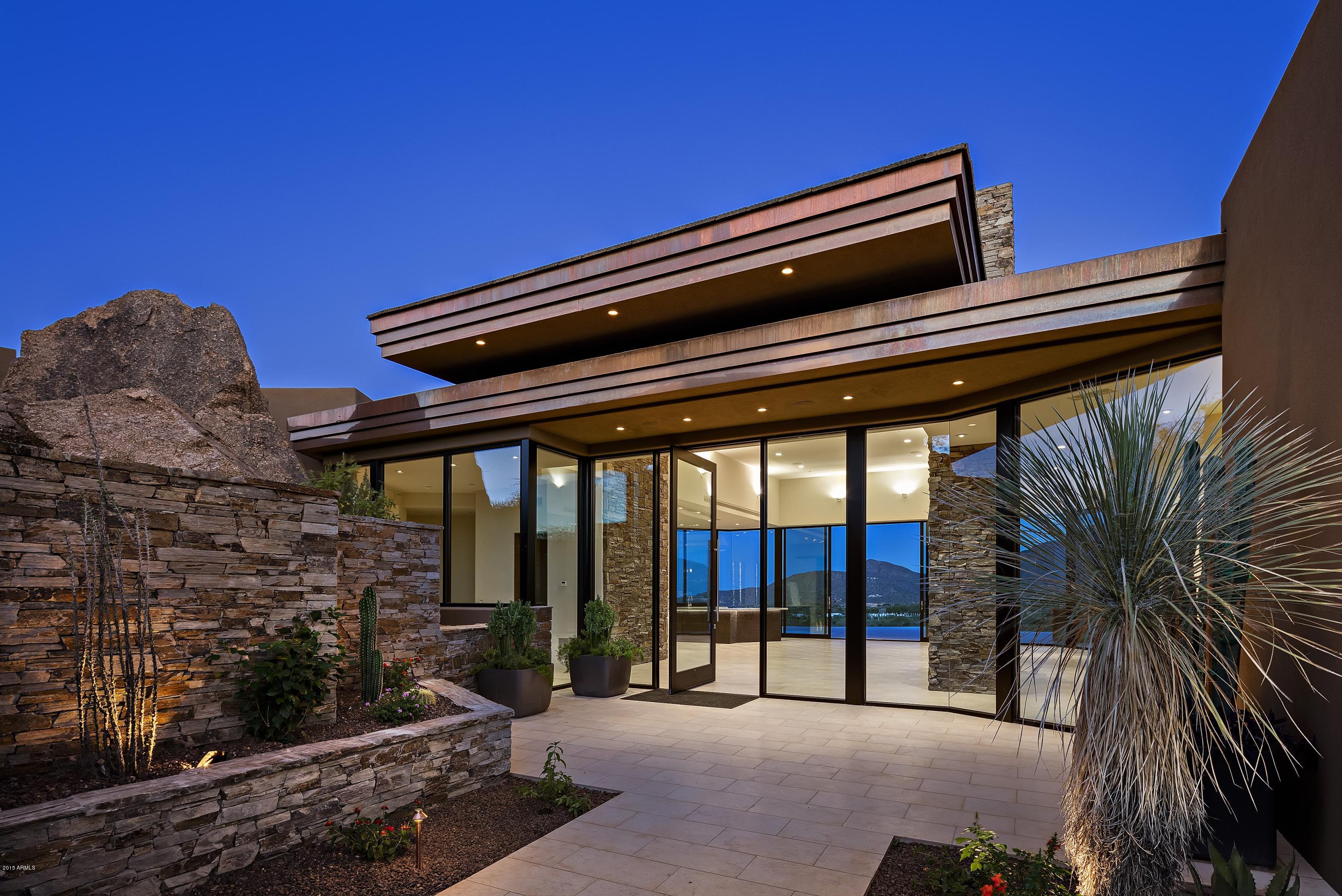 JUST COMPLETED NOVEMBER 2015! This New Desert Contemporary Custom Home built by Dick Lloyd Custom Homes and designed by Shelby Wilson. Home is situated on two lots to complete this fabulous design with 280 degree views from the McDowells to Apache Peak. Amazing city lights, sunsets and mountains views from every room. This site, located at the highest point of Rose Quartz, is situated on the 14th and 15th holes of Cochise golf course, has  5 bedroom/office, 5.5 bath home plus private casita (bonus room or 4th car garage). Home  is 5,429 sq ft and 7,525 under roof. The Builder/Developer spared no expense with the finishes that were created by The Suzanne Biers Company. Desert Mountain Membership included in purchase of home.