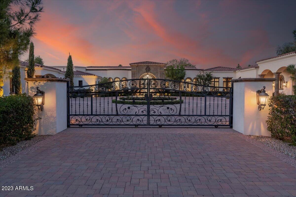Original Owner offering an immaculately designed (by Est Est) and built (by Calvis Wyant Luxury) home on a signature Paradise Valley 2.185 acre private (room to expand) lot. Stunning Architecture and Timeless Design throughout; all on a single level (no steps) including a detached Guest-Home, offering its own living, dining, kitchen, laundry and garage. The main home offers 4 en-suite bedrooms, 2 offices, 3 guest powder rooms, a large sit down bar by the cozy game and wine rooms; separate exercise room, 3 laundry areas, extended covered patio space facing north, heating and misting systems, a total of 6 garages, room to add more livable SF, RV, Tennis, Sport Court and Garages on this 2.185 acre lot. Highly upgraded home: automation and cameras; numerous storage space - See  MOTION VIDEO! Highly upgraded home: automation and cameras; numerous storage space areas and option to add lifts inside the garage.