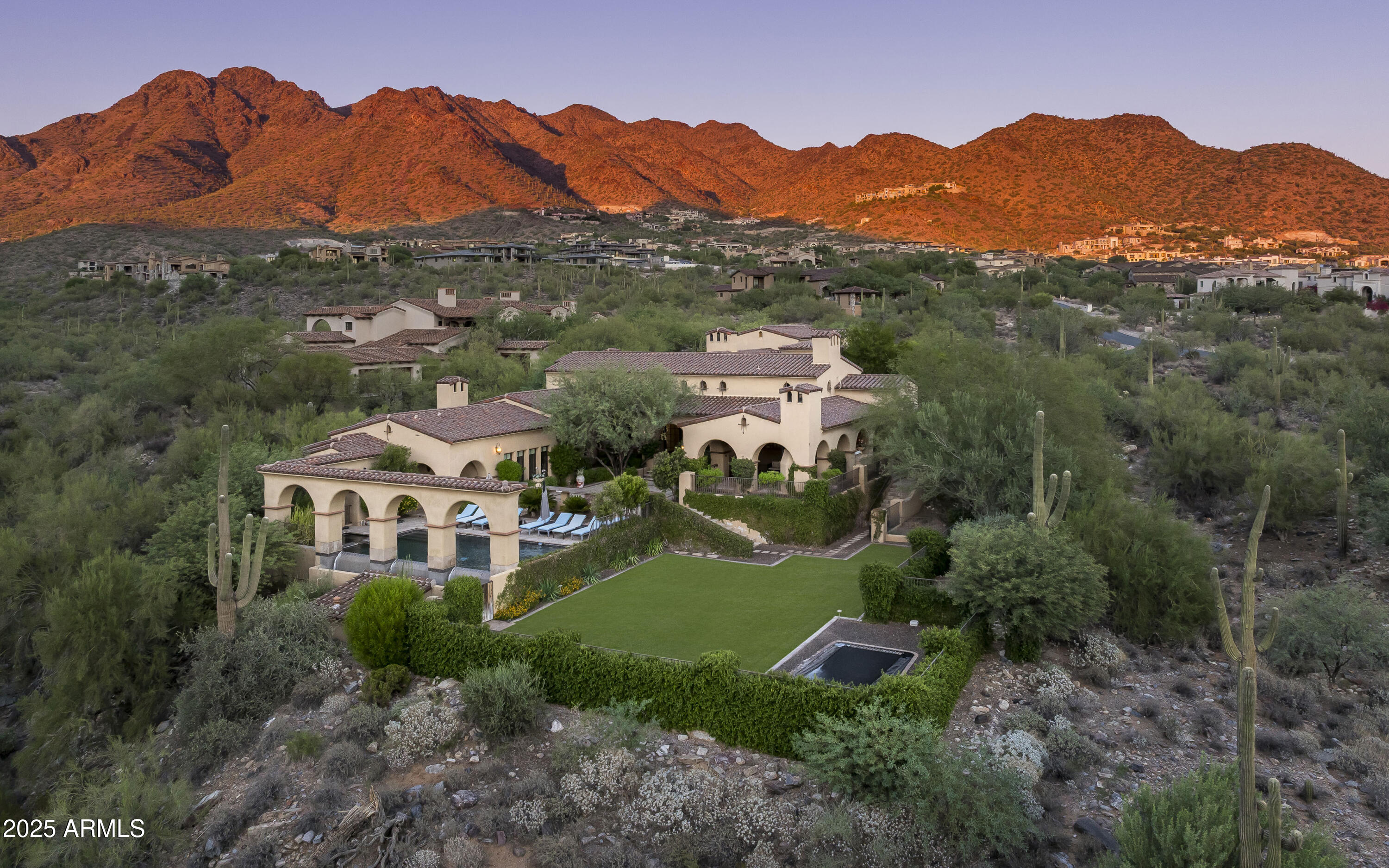 Nestled privately on 2.14 acres in the coveted Upper Canyon of Silverleaf, this exceptional custom estate captures the essence of luxury desert living. Perfectly positioned against the serene mountain preserve, the home offers breathtaking panoramic views of the surrounding mountains, vibrant sunsets, and glittering city lights below. Thoughtfully designed with a seamless blend of comfort and sophistication, the residence features four bedrooms and four and a half bathrooms, including an interior guest casita with a private entrance—ideal for visiting family or guests seeking their own retreat. A gated auto court leads to a four-car garage, offering both privacy and convenience. Inside, every detail has been crafted with care, from the refined architectural lines to the warm, inviting interiors that open effortlessly to expansive outdoor living spaces. Whether entertaining beneath the desert sky or enjoying a quiet evening by the fire, this home embraces Arizona's indoor-outdoor lifestyle at its finest. This is a rare opportunity to own a very livable-sized home on an expansive estate lot, offering exceptional privacy, stunning views, and incredible value in one of Silverleaf's most prestigious enclaves.