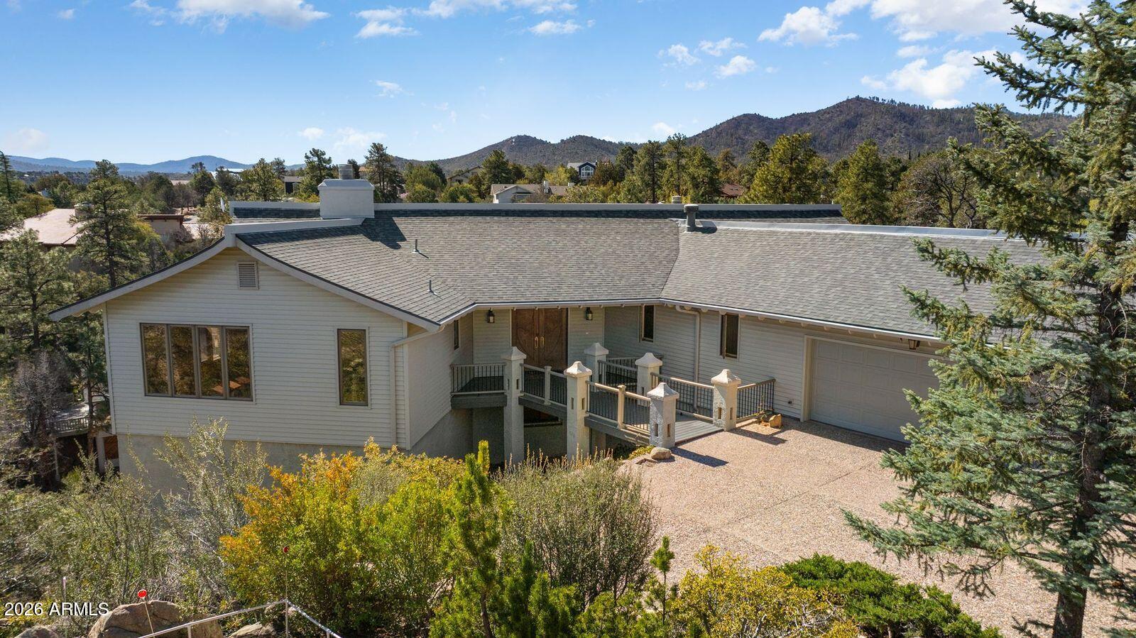 Come home to the tall pines and breathtaking panoramic views of the San Francisco Peaks, Mingus Mountain, the Bradshaw Mountains, and Prescott. A grand entry welcomes you with a staircase leading to the lower level, while the main level offers comfortable living with a spacious master suite. The remodeled kitchen features granite countertops, new cabinets, plus a huge island perfect for cooking with an adjacent great room for gathering. Oversized windows fill every room with natural light and showcase the stunning scenery. Additional highlights include a great room, library, two fireplaces, low-maintenance siding, water tank, and a safe room. Step outside and take in the incredible mountain views from the decks--your private retreat in the pines on nearly a half-acre.