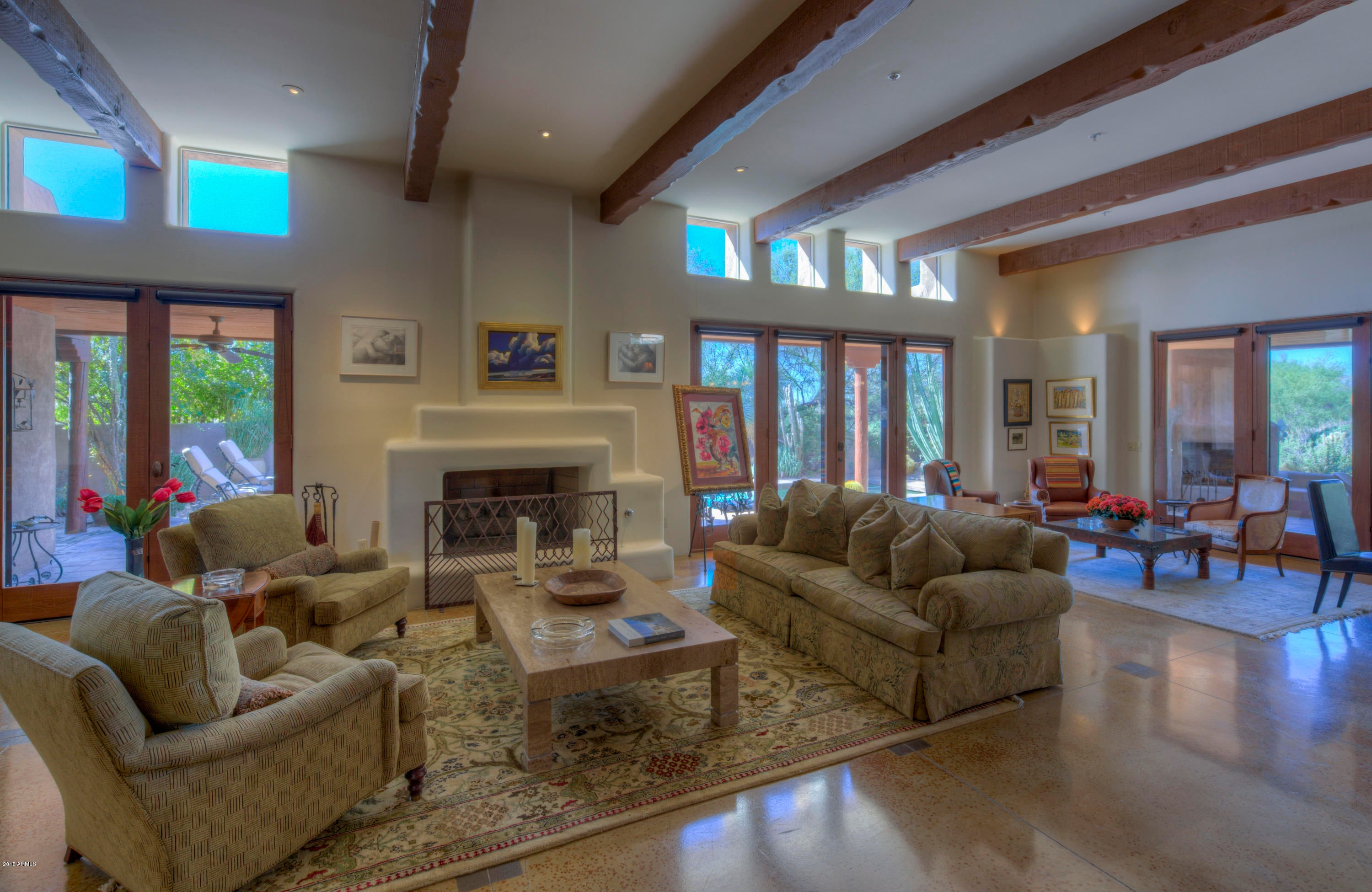 Custom retreat nestled among the lush landscape and boulder outcroppings! The gourmet kitchen features an oversized island, double ovens, gas cooktop, wine cooler, and large walk-in pantry. A cozy library w/ latilla ceiling and built-in bookshelves opens to a dramatic great room with wood-beamed ceilings and large windowed wall providing spectacular views of the renowned boulders. The master suite opens to a lush courtyard complimented by a peaceful water feature. At guest wing, one can swing open a bookshelf that accesses private guest quarters w/ bedroom, bath, living room, fireplace, wetbar, and direct access to the pool and patio area. Enjoy the amazing desert landscapes from multiple outdoor living areas with fireplace, pool and views of Black Mountain, boulders and sunsets.