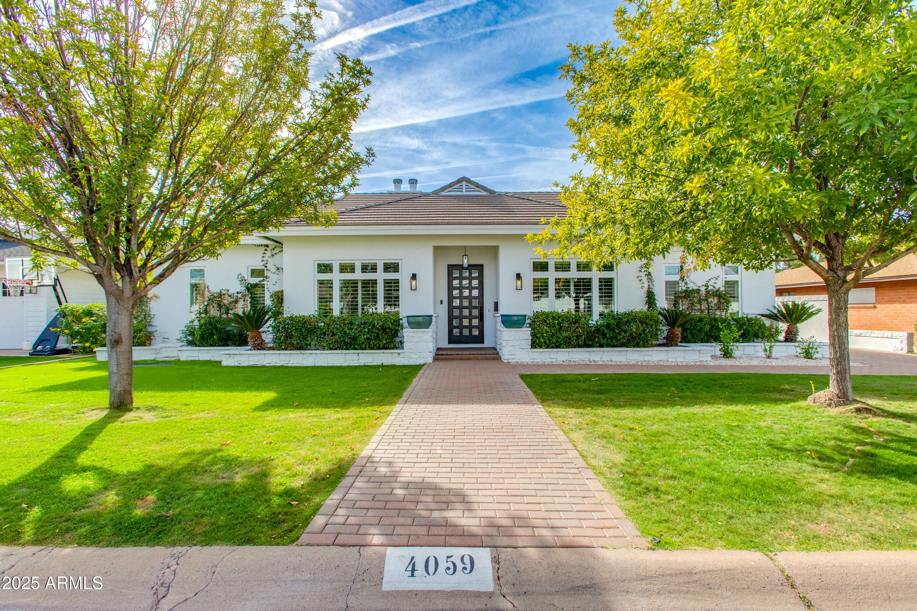 Beautiful custom built 4 bed, 3 bath home in the highly sought-after Arcadia Osborn neighborhood. This 2,625 sqft residence features a split floorplan, formal dining room, and a versatile flex space for a home office or family room. Tile floors flow throughout, while the well-appointed kitchen opens to a living room anchored by a fireplace. Step outside to an expansive covered patio with fireplace, a spa, lush landscaping, and built-in BBQ, perfect for entertaining. Two master suites, each with direct patio access, provide ideal space for guests or in-laws, while additional bedrooms offer flexibility. Complete with a 2 car detached garage, this home blends thoughtful design, modern comfort, and the ideal Arcadia lifestyle, just minutes from top-rated schools, Arcadia hot spots, and more!