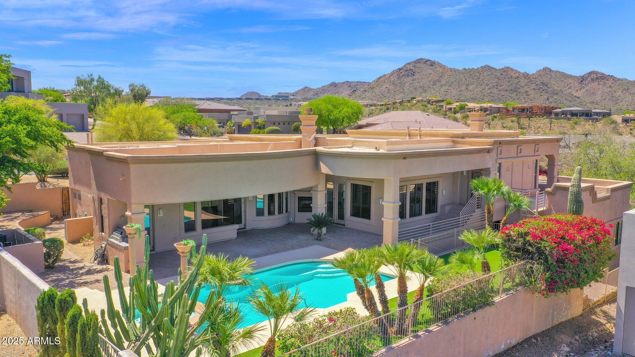 Timeless Elegance with Panoramic Mountain Views in the Sunridge Canyon community! Nestled in the serene hills of Fountain Hills, this stunning custom home is the definition of modern luxury and desert beauty. Sitting on a spacious corner lot, designed to impress, and crafted to the highest standards. This one-of-a-kind residence offers spacious bedrooms, a versatile den, 4.5 luxurious bathrooms, and a private casita that is perfect for guests or multigenerational living. From the moment you arrive, the meticulous attention to detail is undeniable; from the soaring 10- to 12-foot ceilings, abundance of natural light, custom finishes, solid core doors, wood flooring, brand new carpet, and the inviting ambiance created by five indoor and outdoor fireplaces, you'll never want to leave. The chef's kitchen is a showstopper complete with stainless gas Thermidor appliances, built-in refrigerator, custom cabinetry, gorgeous granite, and a huge island with breakfast bar. Entertain your guests in style while serving up a beverage from the luxurious wet bar. The seamless indoor-outdoor flow invites you to enjoy the resort-style backyard, complete with a sparkling pool, elevated spa, built-in BBQ, and multiple covered patios, each designed to capture breathtaking mountain vistas and Arizona's famed sunsets. Entertain with ease on the rooftop deck, where panoramic views provide a stunning backdrop for unforgettable gatherings. 

When you're ready to retreat at the end of the day, head to your lavish primary suite featuring double exits onto the patio, a two-sided fireplace, and a spa inspired ensuite bathroom complete with double vanities, a free-standing tub, luxurious walk-in shower, and custom closet.

Located just minutes from the iconic Fountain Park, award-winning golf courses, and upscale dining and shopping, this exceptional home offers the ultimate Arizona lifestyle you've been waiting for!