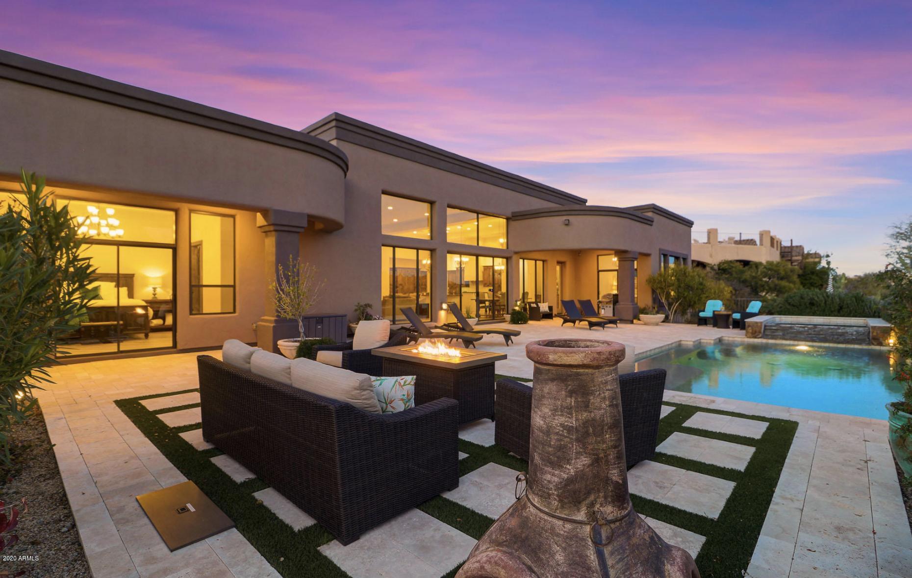 Picturesque mountain views stun in this 2014 built custom home located in the 24-hour guard gated community of Troon Mountain Estates at Troon Village. The open concept great room floor plan features four bedrooms, three and a half baths plus a large game room, ideal flex space for whatever your needs! The great room highlights the McDowell Mountain Preserve views with floor to ceiling windows and doors overlooking the perfectly landscaped minimal maintenance backyard with pool and elevated spa, travertine hardscape, artificial turf inlay, and two covered patios. Inside the home take note of the wood style plank tile flooring throughout, the smooth white walls, stylized light fixtures, knotty Alder wood doors and cabinetry, and high ceilings. The kitchen is an entertainer's dream with an oversized island with white cabinetry, bar seating, leather finish granite tops, custom hood vent, stainless steel appliances including a gas range, matching paneled fridge and adjacent to the dining area. Other features include a three car garage with 240 volt receptacle, new exterior paint in 2019, new foam roof in 2019, LED lighting throughout, large laundry with stackable washer and dryer, split floor plan, new ceiling fans on the bedrooms and living room, Nest thermostat, new landscaping plants in the front and back, and new outdoor landscape lighting. This hillside home has most furnishings available by separate bill of sale. Enjoy everything North Scottsdale has to offer from fine dining to renowned hiking and biking trails.