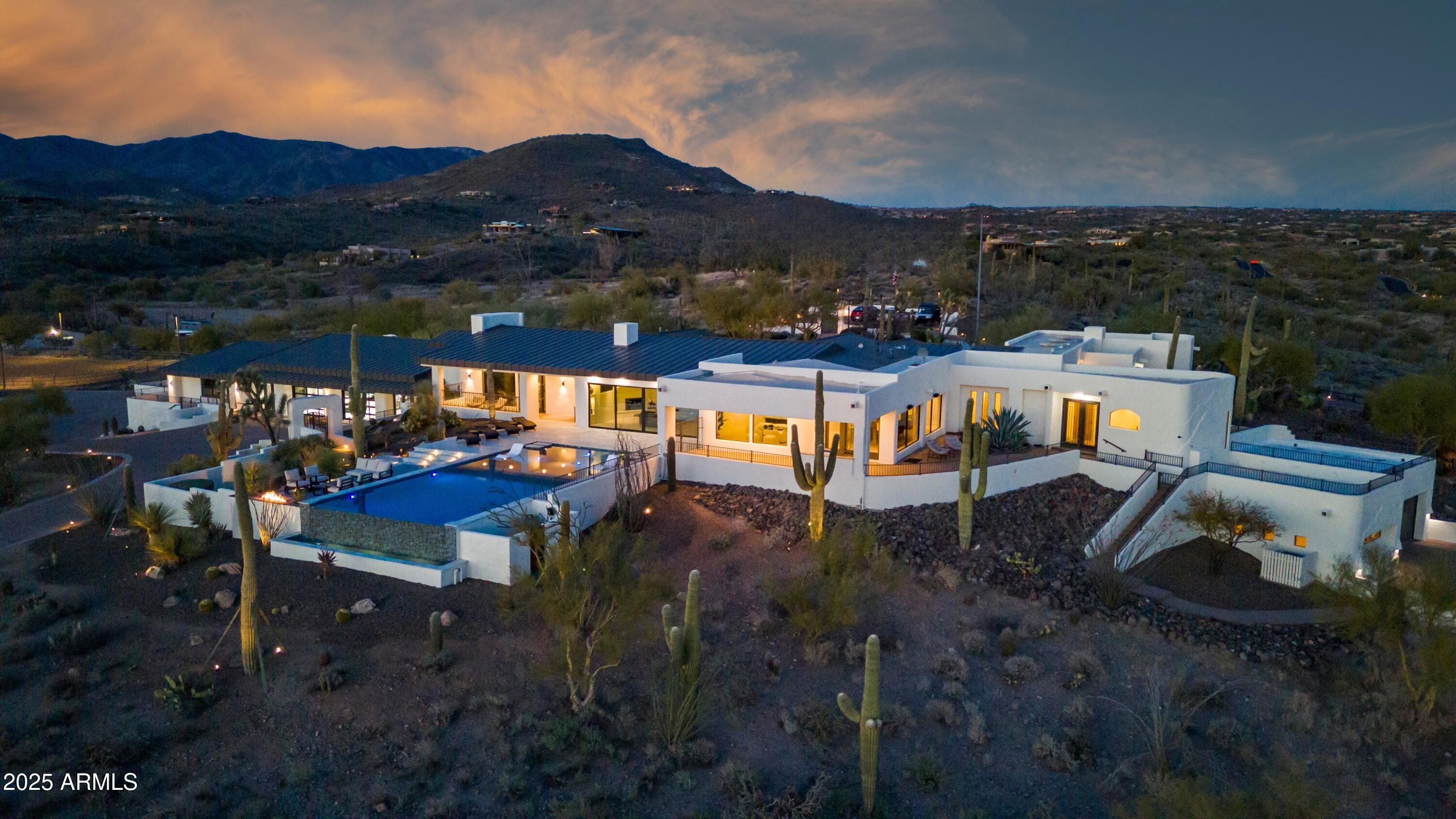 Double R Ranch, a privately gated compound spanning 10 acres, offers breathtaking sunrises and sunsets with 360° mountain views from its perch overlooking the Sonoran Desert. The newly remodeled home has 8 bedrooms and 8.5 baths, with a 9392 s.f. main residence, 1550 s.f. Southwest inspired guest house and 540 s.f. bunkhouse offering the perfect multi-generational private estate.  Constructed with the highest quality materials and well-appointed finishes, this one-of-a-kind property offers a resort-style pool and spa, temperature controlled garages for over 21 vehicles, and full equestrian facilities.  At the north end of the 10 acres is an M&D barn with 6 stalls and runs, feed and tack rooms, and a wash rack  attached to a bunkhouse. Additionally, there is a 200' x 90' lighted arena, and three large turnouts. To store your vehicles in a safe, fully-paved, home environment choose among two traditional garages, a 2700 s.f. pavilion and a 1712 s.f. auto shop with a tool room. Minutes from the eclectic western town of Cave Creek and Scottsdale's upscale attractions, while offering the ultimate in seclusion, Double R Ranch provides car collectors and horse enthusiasts an unparalleled combination of amenities and privacy.