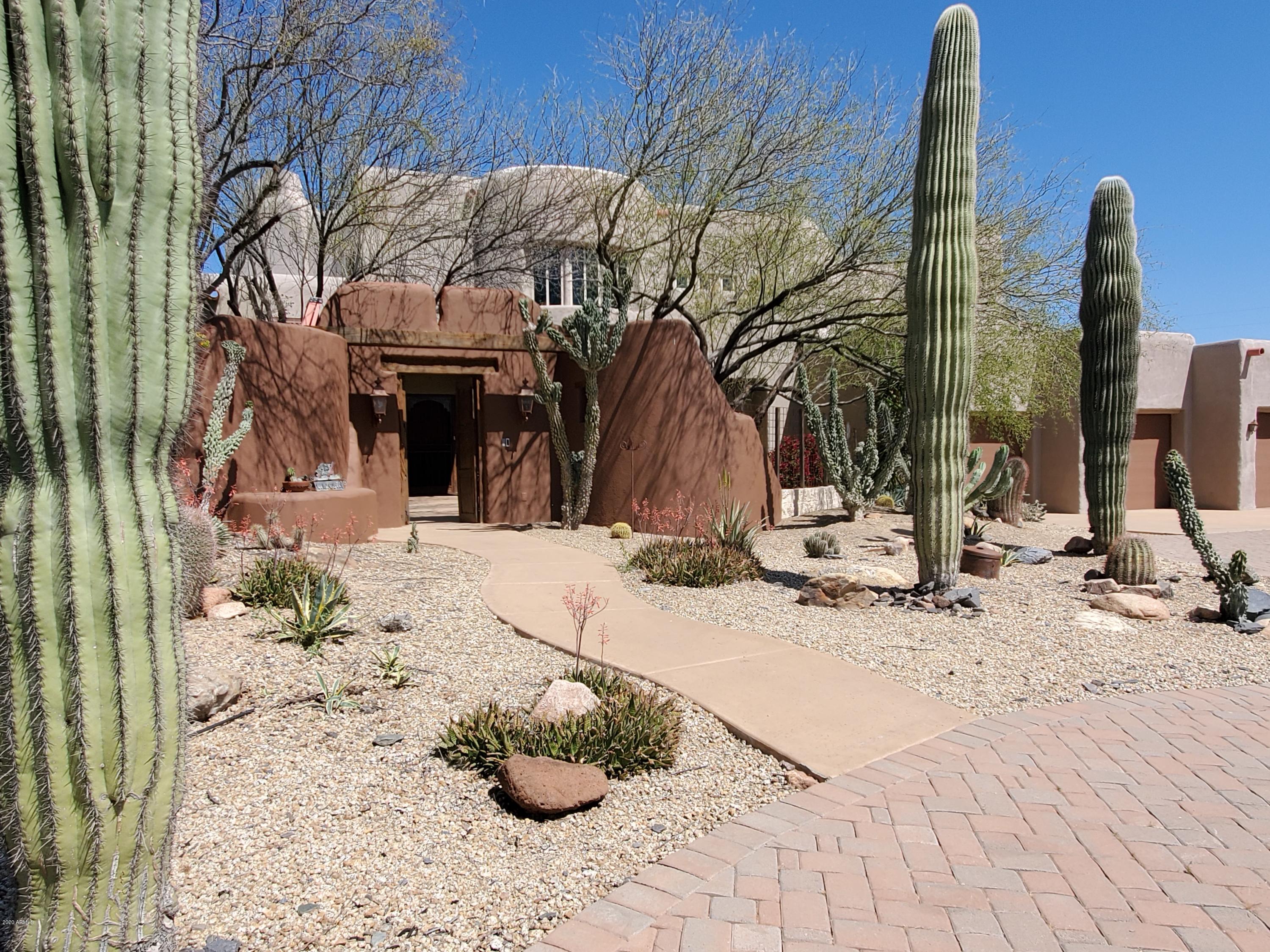 Stunning custom home on one-of-a-kind 5 acre lot divided by canyon. Main house contains 2-story picture windows looking into ravine framed with rough-saw timber from old mine. Separate detached adobe guest house privacy for visitors. Separate RV garage/workshop/hose barn provides plenty of real estate for every hobby.  This home is a must-see.
