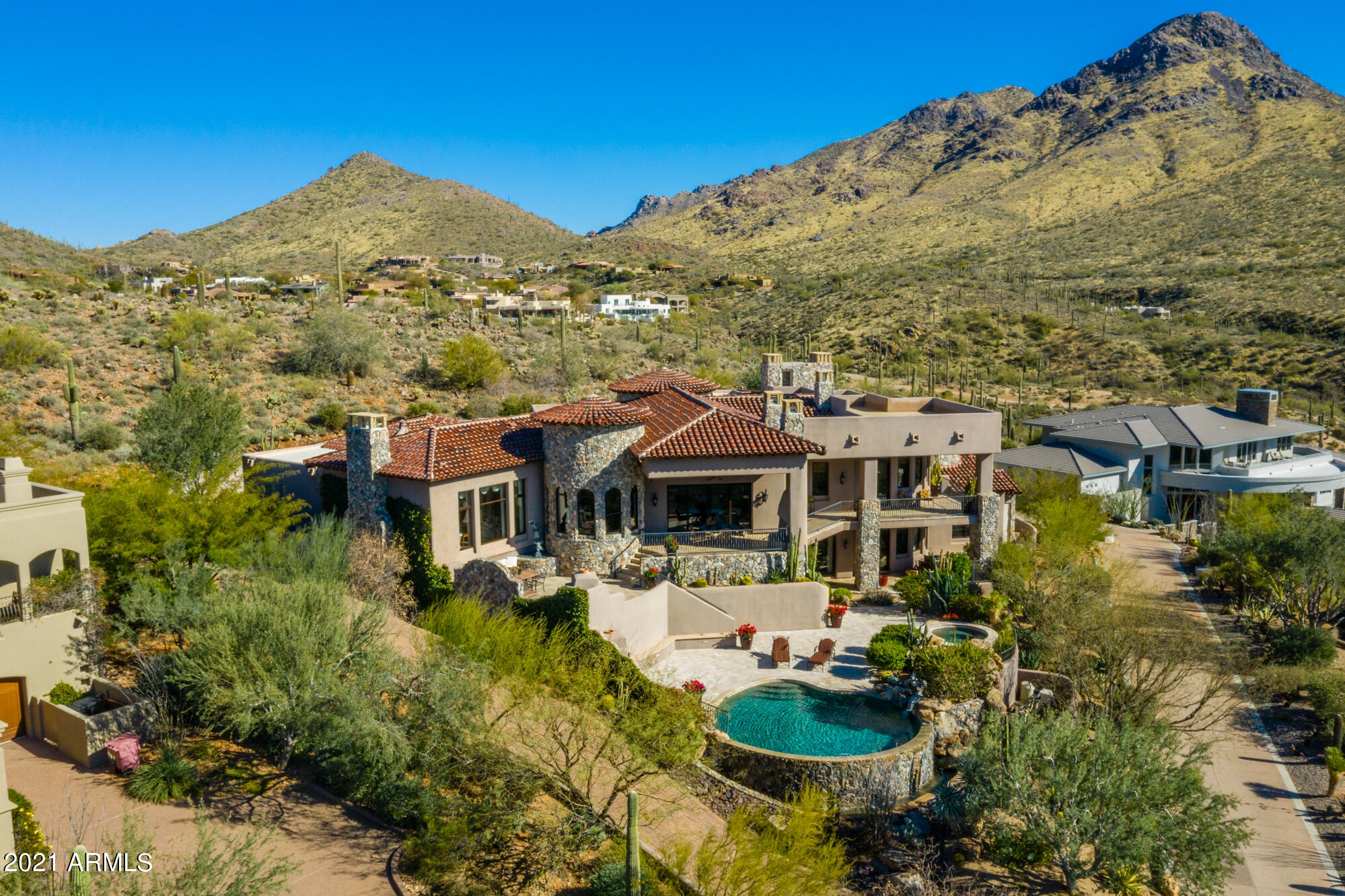 Not to miss! Prestigious Golf guard gated community of Troon, at the highest point of Glenn Moor on almost 2 acres on a quiet cul-de-sac. This gorgeous 8,500 sq ft home has absolutely breathtaking views with city lights, Pinnacle Peak, Troon Mountain, McDowell Mountain & Troon CC Golf course. Highest quality of construction & craftmanship throughout, with the finest finishes, extensive stonework, solid wood beams, barrel & groined brick ceilings, custom mill work. Very unique reclaimed chestnut, Brazilian walnut & mesquite hardwood floors along with Turkish travertine. So many interior elements including Cantera stone artwork niches to admire. You have to see it in person to appreciate the timeless finishes... This home has been designed to provide the best indoor/outdoor living all year long, incredible privacy & tranquility, the opportunity for private family living & entertaining, sliding glass pocket doors, multiples covered charming patios, outdoor kitchen, negative edge pool with rockslide, spa, 3 outdoor gas fireplaces. The most functional Chef kitchen with Wolfe appliances, Sub Zero refrigerator/freezer, walk-in pantry & back prep kitchen. 3 dishwashers, refrigerator & sink, wet bar, plenty of storage, 600 bottle stone & brick wall wine cellar. 5 en-suite bedrooms, including 2 master suites, 2 power rooms, two separate offices, bonus/pool room & additional sitting room with elegant stone fireplace filled with natural light, views are spectacular. Walk downstairs to guest level through a beautiful art gallery staircase, or step in the elevator. All major rooms and master suite are on the main level. Generous 4 car garage, lots of extra storage & a spectacular view deck. Take a short walk over your own hill overlooking the 15th hole of the Troon golf course. Troon CC Golf membership available. So many features to name! I invite you to come and take a tour of this exceptional home. This is a must see in person.