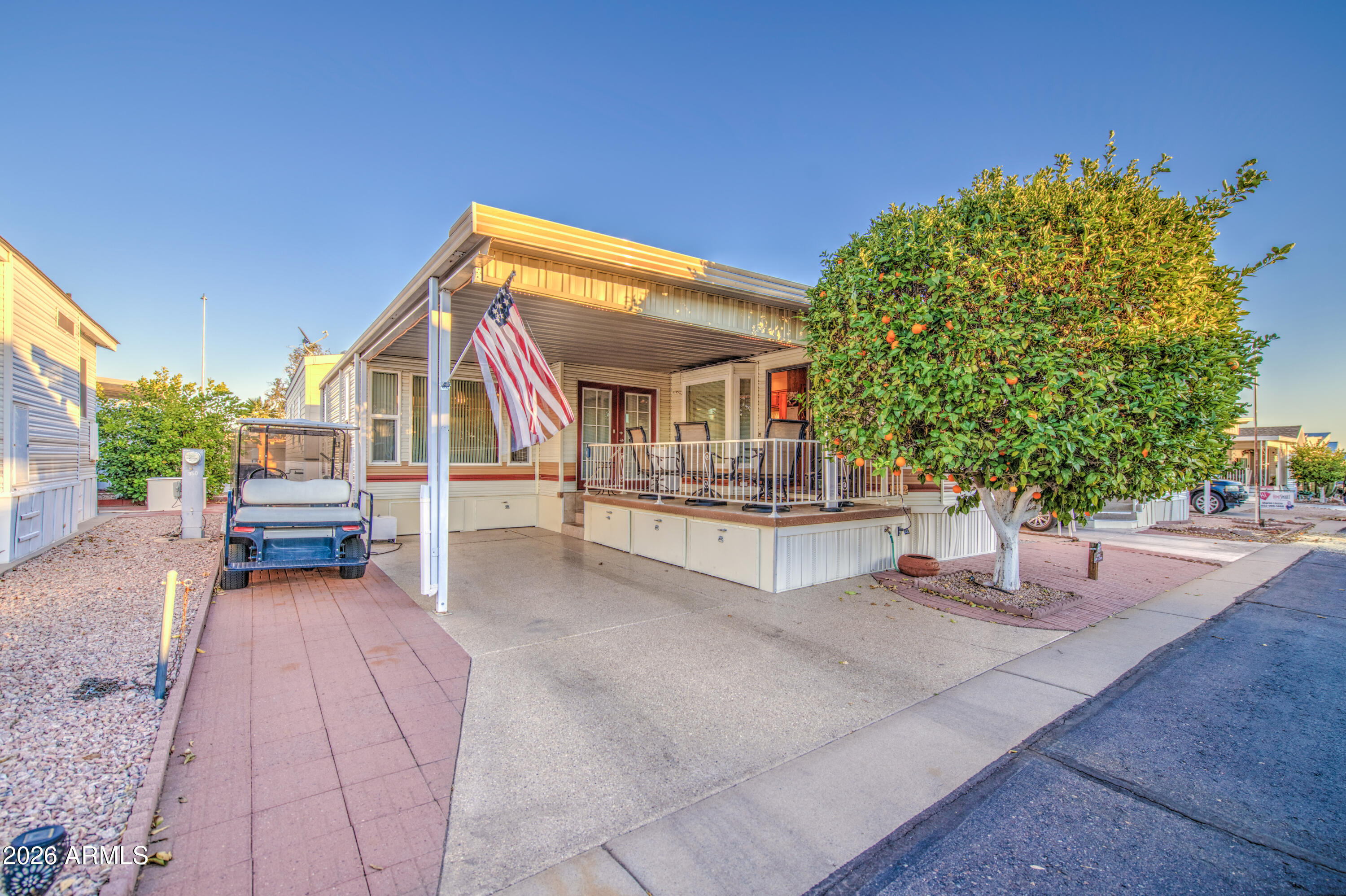 This is a beautiful west facing park model with an Arizona room in Carriage Manor Resort, a premier 55+ Community where you OWN THE LAND! Enjoy sitting on the large deck in the evening and watching the sun set. Large orange tree in front of the home and pavers on the side to park the golf cart that is included with the sale. Outside you have 5 large storage drawers. This home that has dual paned windows also comes completely furnished with new stackable front load washer and dryer in the 2nd bath. Hot water tank only 2 yrs old. Carriage Manor has 24/7 on site security, a heated SALTWATER pool/spa, fitness facility, Tennis, Pickleball, Bocce, Shuffleboard, Golf Club, Billiards, Lapidary/Silversmith, Ceramics, Glass Art, Sewing, Wood shop, Bingo, Dances parties & many more activities & amenities.