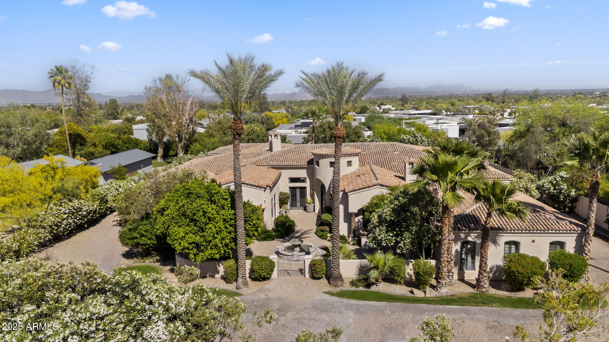Nestled in one of Paradise Valley's most sought out neighborhoods, this gated estate offers over 6,800 sq ft of refined living space with scenic Camelback Mountain views.  The main residence features 5 bedrooms, 5 bathrooms, and an attached guest house. A grand courtyard with fountain and firepit welcomes you. Inside, enjoy 3 fireplaces, including one in the primary suite. Two separate garages a 3-car with private drive-up and a 2-car on the opposite side--cater to car enthusiasts. Automatic glass pocket doors open the living area to an outdoor terrace, and the kitchen's pass-through window serves the pool area. Outdoor amenities include a sparkling pool, rejuvenating spa, and private basketball court, perfect for entertaining under the Arizona sky. Nestled in one of Paradise Valley's most prestigious neighborhoods, this exquisite gated estate offers over 6,600 square feet of meticulously designed living space on more than an acre of lush, landscaped grounds with scenic views of Camelback Mountain. The main residence features four spacious bedrooms and four luxurious bathrooms, complemented by an attached guest house providing additional accommodations. A grand courtyard entrance welcomes you with a tranquil fountain and a cozy firepit lounging area, setting the tone for the elegance within. Inside, three fireplaces enhance the home's warmth and ambianceone gracing the primary suite and two others situated in separate living and entertainment areas. The estate boasts two separate garages: a four-car garage with a private drive-up and a separate two-car garage on the opposite side of the residence, catering to car enthusiasts and hobbyists alike. Automatic glass pocket doors seamlessly open the living area to the outdoor terrace, creating a fluid transition between indoor and outdoor spaces, while the kitchen features automatic glass pocket windows serving as a convenient pass-through to the pool area, perfect for entertaining guests. Enjoy resort-style outdoor amenities, including a sparkling pool, rejuvenating spa, and a private basketball court, all designed for relaxation and entertainment under the Arizona sky. This Paradise Valley gem combines luxurious living with the charm of Arizona's desert landscape, offering an unparalleled lifestyle opportunity.