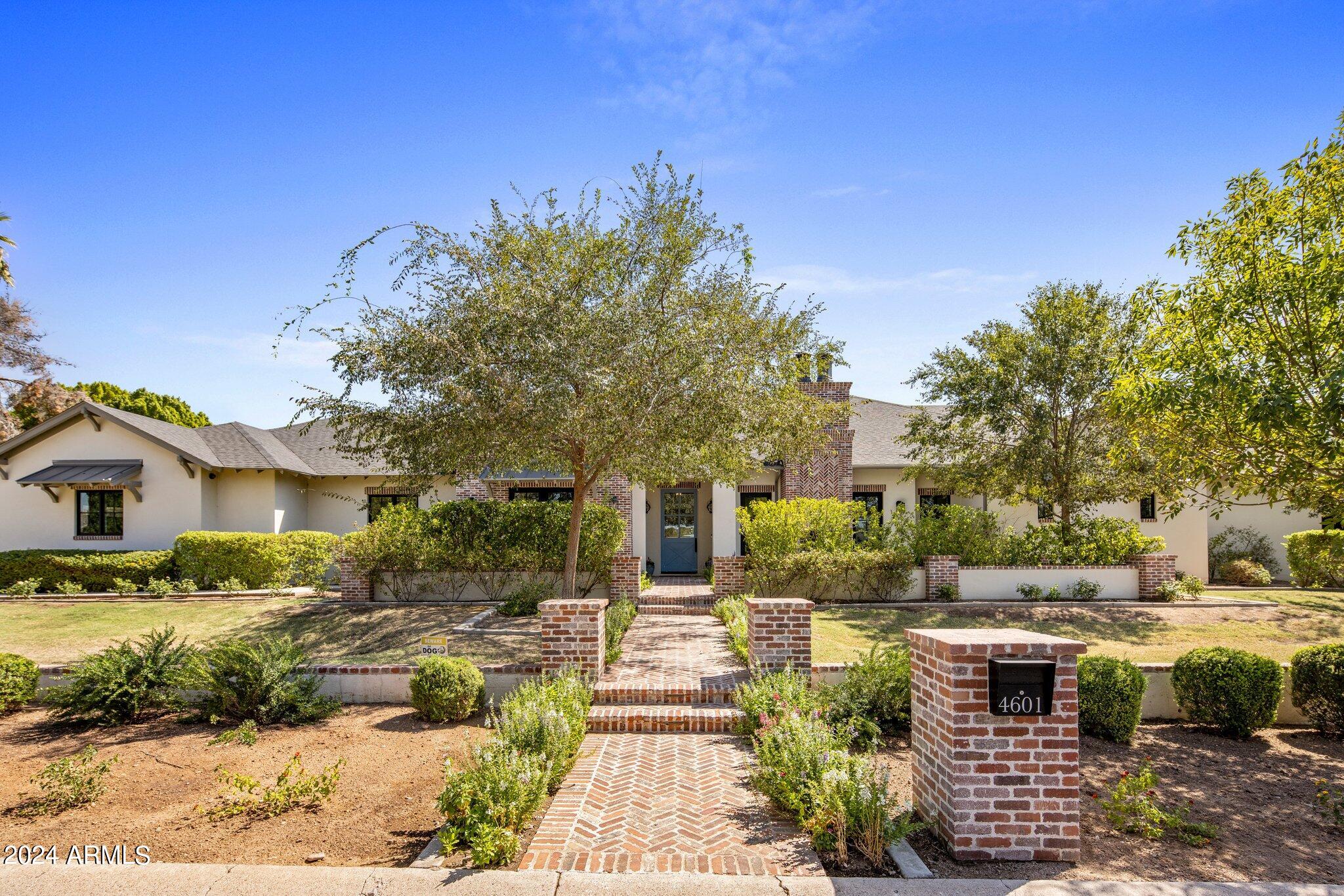 In the heart of Arcadia proper, the most exclusive and desirable neighborhood in Phoenix, this modern farmhouse built in 2017 is the perfect family home. Featuring 5764 sqft on .61 acres (all one level, no interior steps), the masterfully designed floorpan offers 5 bedrooms, 5.5 bathrooms, formal & informal entertaining areas, an office, & a playroom/flex room (playroom can easily be converted to a 6th bedroom). The enchantment begins at the curb where a lovely brick walkway leads to front courtyards including a picture-perfect outdoor living room with a very special exterior fireplace. Upon entering, take in the warmth of the textures from hardwoods to brick accents, hand-cut beams and tasteful wall paneling. The great room is the heart of the home with abundant space for entertaining, dining & lounging. The chef's kitchen features designer finishes, requisite appliances (Sub Zero, Wolf), and a bar with gravitas. The lush backyard offers views of Camelback Mountain, a saltwater pool, spa, outdoor kitchen, plus plenty of grassy areas for play. The primary suite with a private den is a romantic escape at the end of the day.  Other pertinent details include: Control 4 home automation and speakers inside & out. Owned 18.72 kW solar added in 2022 (near net zero) with integrated battery system. 3-car garage with huge workshop area and Tesla charger. Perfectly located equidistant (3 miles) to Old Town Scottsdale and also the Biltmore, Arcadia offers suburban charm with urban convenience. There is a unique sense of community here where neighbors strolling and biking is the norm. Walk to Hopi Elementary School and only 1.7 miles to Phoenix Country Day School. 6.2 miles to Sky Harbor Airport and 11.6 miles to Scottsdale Airport.