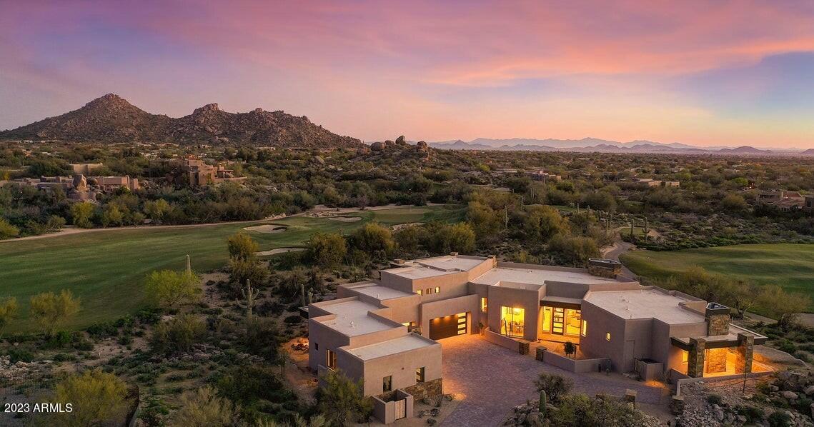 Golf Membership Available! Stunning Contemporary masterpiece that redefines luxury living. Located within the prestigious Reserve at The Boulders community, this stunning 3-year old custom-designed home offers a private, luxury lifestyle beyond comparison. Overlooking the 14th and 18th holes of the renowned Boulders ''South Course'', this home provides privacy along with dramatic 270-degree awe-inspiring views that never disappoint from stunning sunrise that stretch across the golf course fairways, the Sonoran Desert and Valley, around to the blazing sunsets beyond. 

Prepare to be captivated by the epitome of opulence, this home is an entertainers' paradise. This home has clean lines and an abundance of floor-to-ceiling disappearing windows that seamlessly welcome breathtaking views into every living space. 
Stunning open great room architecture with soaring ceilings, Premium European Oakwood-flooring, and walls of glass to the outdoor patio and living space. The Chef's kitchen is a masterpiece with top tier Sub-Zero, Wolf and Miele appliances, custom cabinetry, warming oven, and a walk-in pantry. Two large double quartz islands designed for entertainment provide extensive counter space, bar seating and extra cabinets for storage. Enjoy exquisite formal dining off the great room, or the casual Arizona indoor-outdoor lifestyle in the open dining space off the kitchen with patio access. Step through the walls of glass outside to a backyard entertainers oasis for a dip in the pool, spa or relaxation under the expansive covered patio complete with outdoor dining, overhead fans, misters, and built-in heaters for year-round comfort. Open view fencing allows exquisite desert, sunset and mountain vistas at the same time protecting the privacy of the home. Enjoy culinary delights on the built-in Lynx Stainless Steel BBQ, gather around the inviting fire pit, and take in the splendor of the reverse infinity negative edge pool and attached spa perfect for stargazing at night. 
 
Luxurious Owners Retreat: 
Back inside, as you walk past the exquisitely designed powder bath, you come to the luxurious owner's retreat and office which is thoughtfully separated from the other two bedrooms in the main house. The spacious primary bedroom with fireplace and outdoor access to a private patio with golf course, sunset and mountain views invite rest and relaxation. The luxury bath boasts a freestanding tub, separate vanities, one with make-up space, walk-in shower, separate water closet, his and hers walk-in closets and a personal washer and dryer delivering ultimate lavish living. Enjoy true single level living with all main living areas, great room, owners wing, office, casita, and indoor/outdoor living spaces all on one level. Two beautifully appointed ensuite bedrooms, one with full lounge area, breakfast bar, are found in the opposite side of the home. Relax and watch the sunrise and step out onto the wrap-around covered observation patio to experience the gorgeous setting of mountains, golf course, desert, and city light views.  
 
Private Casita: 
The very private separate casita features a fully functional kitchenette, separate sitting area, luxurious ensuite bathroom, in-unit washer and dryer, and a private patio with more incredible views. The casita also offers a separate 4th car garage for your guests. 

Luxury Garage
The luxurious owners 4-car oversized air-conditioned garage area with car charging port, epoxy floors, tons of storage cabinets can be easily expanded to 4-car capability with pre-designed lift. 

Smart Home Living
This "smart home" epitomizes modern convenience with the Control4 system, seamlessly integrating Lutron lighting, HVAC systems, the operation of the pool, spa and misters, electronic shades, surround sound, fireplace, ceiling fans, and more.

Experience Virtually
To fully appreciate the grandeur of this home, we invite you to experience it virtually with extensive photos, a 3D virtual tour, and overhead aerial views of the home's beautiful surroundings. Contact us today to embark on this journey of luxury living redefined. Your dream home awaits.