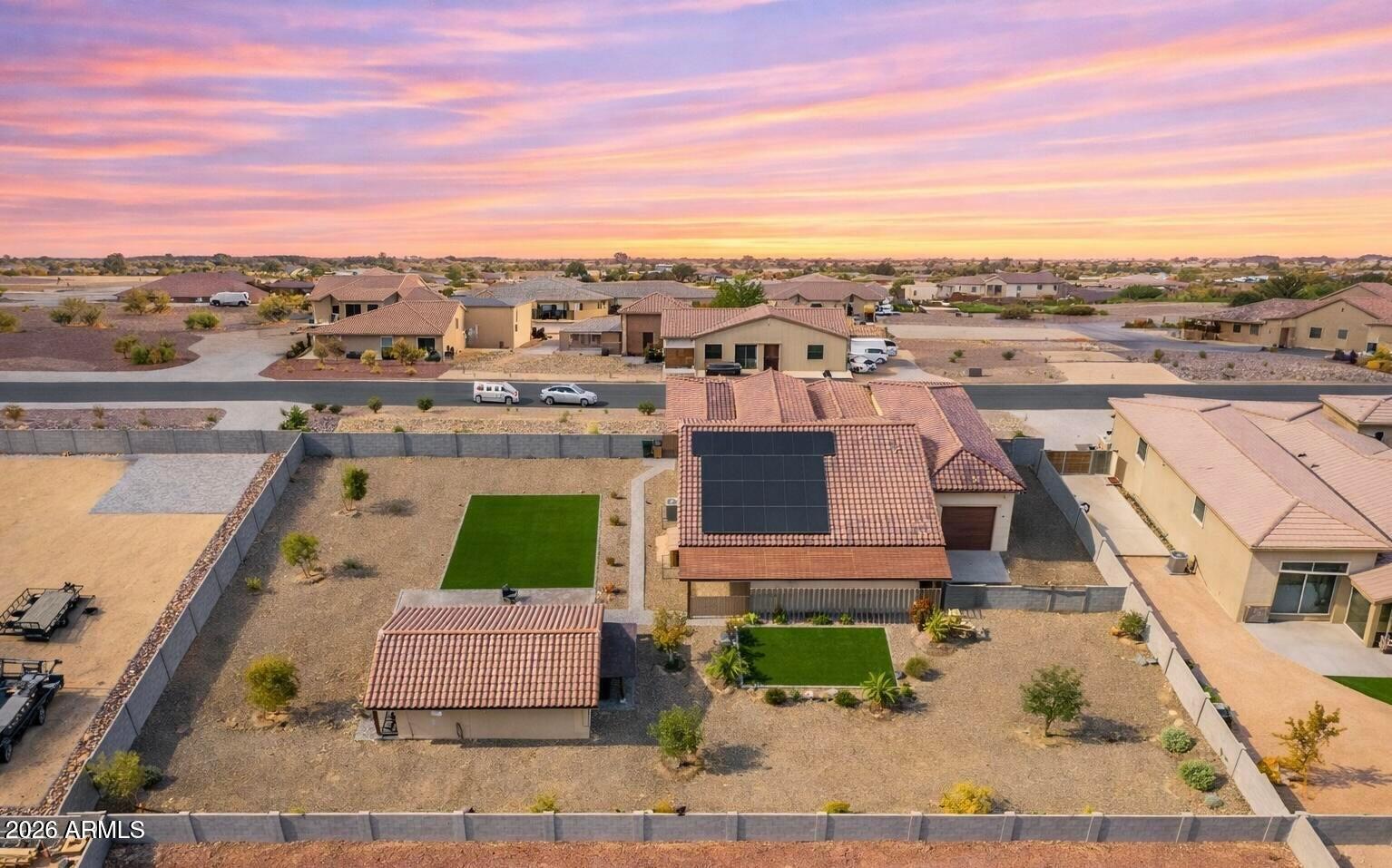 Set on nearly an acre of lush, manicured grounds in sought-after Luke Ranch Estates, this exceptional residence blends refined style & everyday comfort enhanced by a fully owned solar system for energy efficiency. From the moment you arrive, the impressive curb appeal & expanded cobblestone driveway hint at the thoughtful upgrades found throughout. Inside, a warm, inviting interior showcases a neutral palette, elegant Union Stone tile flooring, upgraded carpet in the bedrooms, 5¼'' baseboards, & custom blinds & window treatments. The spacious Great Room & Casual Dining Area are perfectly positioned to capture serene views of the beautifully designed backyard. The chef-inspired Kitchen is both functional and stunning, featuring 42'' cabinetry with dovetail, soft-close construction, sleek quartz countertops, an oversized island with bar seating & added storage, plus a premium Samsung stainless steel appliance package including a convection oven & upgraded induction cooktop. The Primary Suite offers a true retreat with a generous walk-in closet & a beautifully upgraded, enlarged shower with frameless 3/8" glass surround. Two additional bedrooms with walk-in closets, a versatile Office/Den (ideal as a formal dining space), & an expansive laundry room with abundant storage complete the main home. Step outside to enjoy seamless indoor-outdoor living. The extended covered patio, custom pergola, & paver walkways create multiple inviting spaces for relaxation & entertainment, all surrounded by low-maintenance landscaping with turf, trees, plants, & a full irrigation system. A standout feature of this property is the stunning ~750 sq ft Guest House, offering a private retreat complete with its own Great Room, Bedroom, full Bath, and a fully upgraded Kitchen with quartz countertops and Café appliances, including an induction cooktop. A spacious front porch with sunshades enhances comfort & privacy. Additional highlights include a 3-car tandem garage, an Extended, Fully Insulated and Temperature-Controlled 52-foot RV Garage, RV Parking, plus expanded parking. This one-of-a-kind property offers space, versatility, & upscale living, an exceptional opportunity not to be missed.