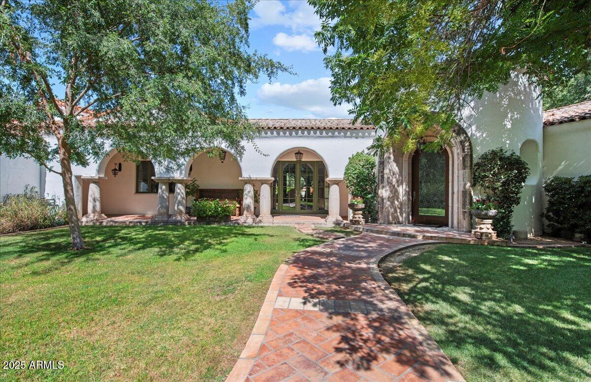 This beautiful Santa Barbara revival built by the talented team at Nance Construction was designed with the purity and character you'd expect from authentic Spanish architecture. As you arrive through the grand entrance, you'll be treated to a home rich with style that seamlessly integrates from room to room with similarity, yet individuality offering a rich array of comfortable, yet luxurious elements. The chef's kitchen has a large island kitchen, custom blown glass front cabinetry, lovely tile accents, Viking six burner stove, oversized Subzero refrigerator/freezer, and separate icemaker. The great room features a gorgeous stone fireplace that serves as a powerful focal point to the room's dramatic design, the formal dining room is a fantastic space big enough for large scale(see more) entertaining, and all the bedrooms and baths have their own unique touches. The quality throughout the home is impeccable featuring wide plank wood flooring, exposed wood beams, authentic ceramic tile, solid wood doors, custom lighting, art niches, built-in cabinetry and hand carved Cantera stone. There's also a spacious casita with a full kitchen and bath perfect for a pool house, art studio or teen room, and not to be overlooked are the lush highly manicured grounds  that feature meandering lawns, sprawling patios, a large covered ramada, huge water feature, and a stunning lap pool. This home is for those who appreciate quality, understand design purity and love comfortable living!
