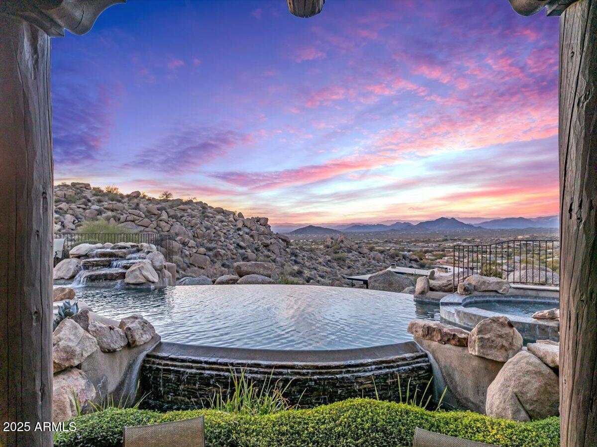 It's all about the views! Welcome to 10473 E Greythorn Dr, an exquisite estate nestled in Scottsdale's prestigious Pinnacle Canyon at Troon North. This elevated 6,577-square-foot residence offers unparalleled mountain, golf course, and city light views, including vistas of Pinnacle Peak and the renowned Estancia and Troon North golf courses.

Built in 2005, this meticulously crafted Crestron smart home features an open floor plan with four spacious bedrooms and seven luxurious bathrooms. The chef's kitchen is a culinary masterpiece, complete with a dining area, butler's pantry, and morning room. Entertainment options abound with four indoor fireplaces, two outdoor fireplaces, and multiple fire pits, creating a warm and inviting ambiance throughout. The primary living spaces and bedrooms are conveniently located on the main floor, ensuring ease of access and comfort. A second-floor media room or executive office, equipped with a full bath, opens to an outdoor patio featuring a fireplace, perfect for intimate gatherings or quiet reflection. Complete permitted and HOA-approved plans for a second-floor bar addition, including a covered patio, are available. The owner will include windows and 23' accordion sliding glass doors for this project.

The property includes a four-car garage with ample additional parking space. The outdoor area is an entertainer's dream, boasting an infinity pool and spa, a covered kitchen and dining area with a fireplace, and a detached casita with its own kitchen, dining space, and private patio offering breathtaking city light and golf course views.

Experience the epitome of luxury living in this exceptional Scottsdale residence, where every detail has been thoughtfully designed to provide an unparalleled lifestyle.
