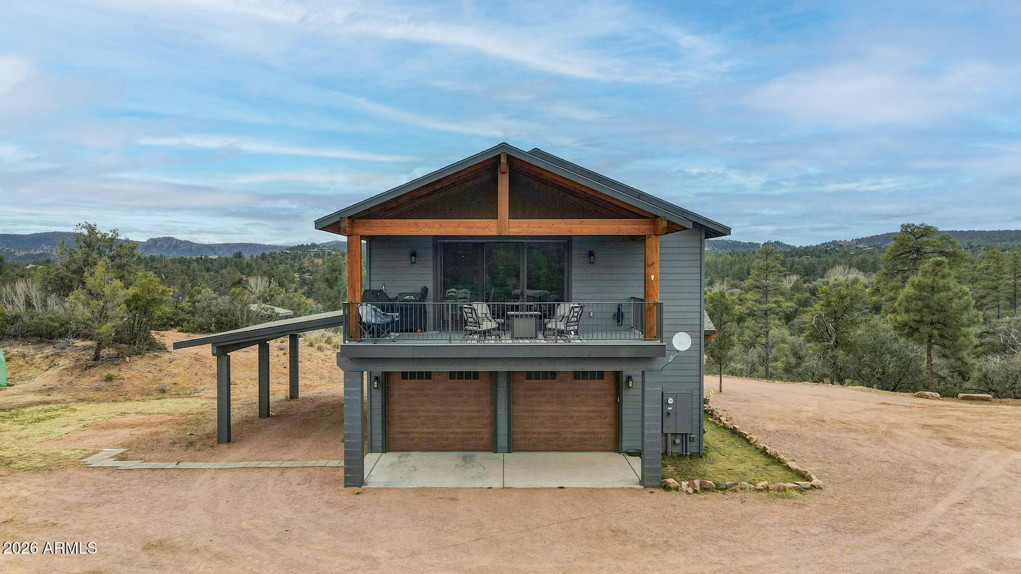 Private 6-acre property with sweeping panoramic views, exceptional future potential and horse privileges. Ideal for a private rural lifestyle, a family compound, or a horse-friendly rental. The land includes a large, cleared pad for a future custom home, along with a private well producing over 20 gallons per minute, a 1,550-gallon storage tank, a booster pump, and a pressure tank in a separate pump house ready to service a new custom home as well as the entire property. The 400-amp electrical service panel that's in place will support the new future custom home as well.  
A no-maintenance alternative septic system is installed and engineered to support a future 4-bedroom, 3-bath custom home along with the existing house. This provides a significant head start on building your dream home while enjoying the current home immediately. The like-new 2-bedroom custom home, completed in 2022, offers approximately 1,200 sq ft of upscale living with quartzite countertops, custom clear hickory cabinetry, solid alder doors with alder trim, upgraded Marvin windows, spray foam insulation, luxury vinyl plank flooring, an oversized walk-in tile shower, and an on-demand tankless water heater for endless hot water. A large covered deck with a powder-coated steel handrail provides the perfect place to enjoy the expansive mountain views.
A large four-car garage includes its own split heating and cooling system for efficient climate control, making it ideal for a workshop and providing plenty of storage. The acreage can be subdivided into two-acre parcels, increasing future potential and offering flexibility for additional homes or a multi-home family compound.
The land is ideal for horses, RVs, and outdoor recreation, offering privacy, space, and room to grow. This is a rare opportunity to enjoy turnkey living now with outstanding future potential, whether for your dream home, a family compound, or multiple two-acre parcels.