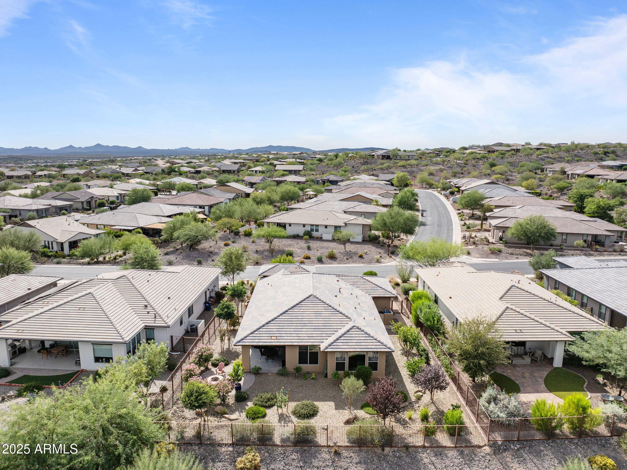 This beautifully upgraded 2-bedroom, 2-bath home offers the perfect blend of comfort, style, and functionality. The open floor plan highlights a spacious kitchen with upgraded GE Café stainless steel appliances, quartz countertops, and elegant cabinetry. Wood-look tile flows seamlessly throughout, complementing the home's modern desert aesthetic. A dramatic corner of retractable sliding glass doors fills the great room with natural light and opens fully to the covered patio—creating effortless indoor-outdoor living.

The primary suite features a spa-like bathroom with quartz countertops and decorative tile surrounds, while the cozy guest suite provides privacy and comfort for visitors. A den with French doors offers flexibility as a home office or guest space. Custom Hunter-Douglas woven shades enhance every room, adding a refined touch and energy efficiency.

Situated on a large premium lot with wide side yards, open space behind, and distant views of the Weaver Mountains, this property offers both beauty and potentialthere's even room to add a pool. Outdoor living is easy with low-maintenance desert landscaping, retractable sun shades, and a fire pit for year-round enjoyment. Additional highlights include a 3-car garage with a full bank of storage cabinets, a 30-amp RV outlet, and a location just a short walk from the lake and mailboxes.

Blending thoughtful upgrades with relaxed desert living, this home is ready to enjoy from day one.
