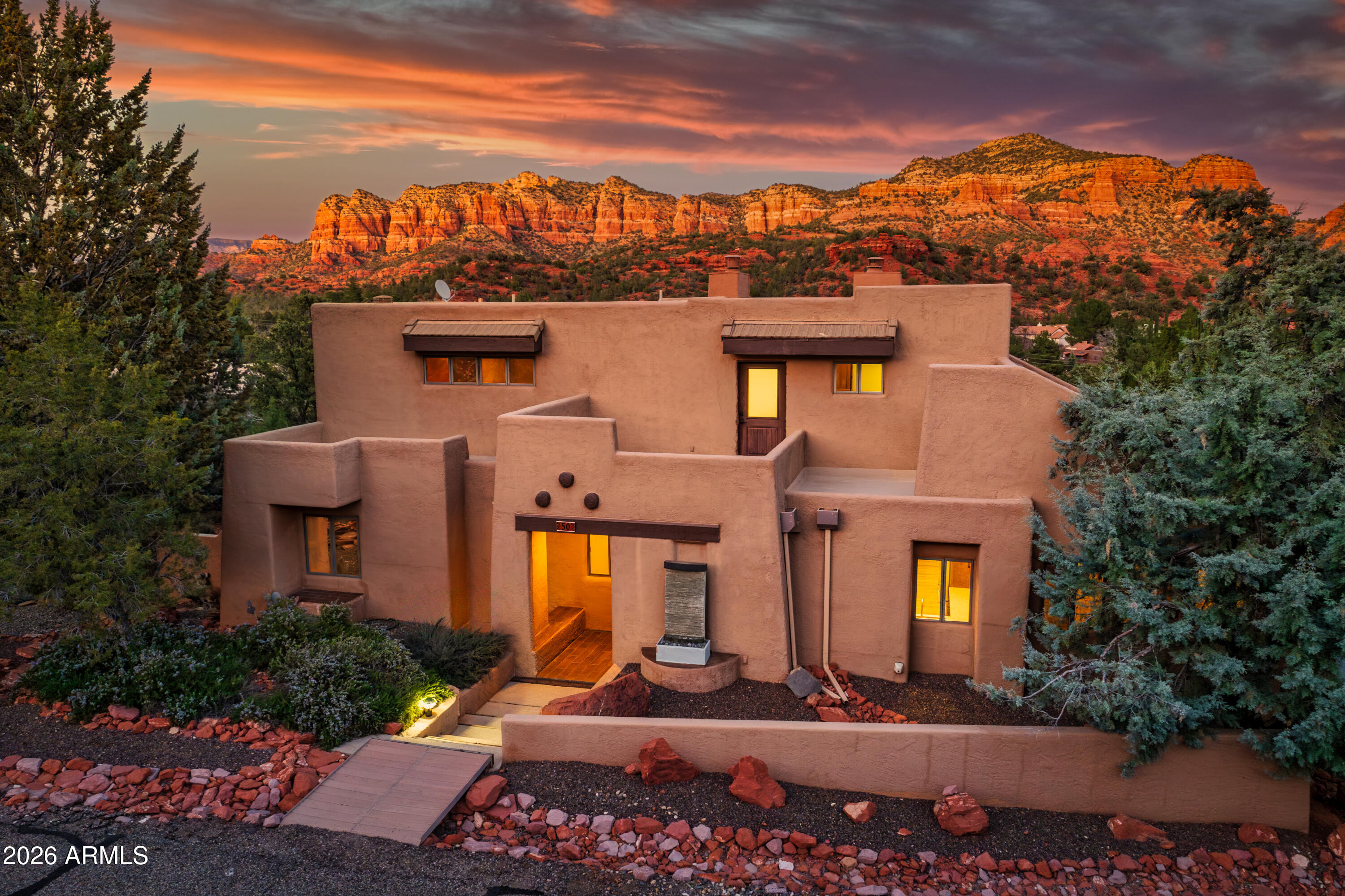Dreamy home that allows short term rentals and has views that must be experienced. Light & color & red rock vistas pour in from every window. Perched at eye-level with some of Sedona's most magnificent formations, this home lives in harmony with its surroundings.

At its heart, an impressive great room  blends kitchen, dining, & cozy living space, that converge with the huge open deck where sunsets linger and mornings can't come fast enough.

3BD, 3.5BA, & a loft that accesses the upper deck, there's space to breathe and gather.  

The lower level has a 2-car garage + two additional bays-ideal for creating a totally tricked-out rec room & gym that will maximize the amenities found only in luxury rental homes.

Let your vision elevate with the view.

MORE DETAILS+PHOTO NARRATIVE: -------------------------------

50 BLACKJACK DRIVE HIGHLIGHTS & DETAILS:

Now with the ability to do short-term rentals, this SW-style gem offers maximum flexibility! Built into the hillside on an elevated .27-acre corner lot, this home feels both grounded and quietly tucked away. Mature trees create unexpected privacy for a residence wrapped in generous glass, offering seclusion without sacrificing light. Distinct Southwest architecture defines the exterior stucco, header beams, viga poles, flat rooflines, and pitched tile-roof planes add sculptural dimension. Gravel, native stone, and regional plantings echo the surrounding landscape, creating a low-maintenance yard that feels authentically connected to the wild beauty beyond. It's almost guaranteed that most days will end on the expansive main-level deck, where Northern Arizona's pristine air and panoramic views take center stage.

This is a three-level home with the main level of the home at street level. Inside, the home is move-in ready with fresh paint and thoughtful renovations throughout. Luxury vinyl plank flooring flows beneath vaulted wood ceilings and exposed beams, creating a timeless warmth. The interiors carry a rugged elegance clean, cohesive, and texturally rich where comfort and design live in balance. Every room feels peaceful & captures a view.

MAIN LEVEL FEATURES:

GREAT ROOM & KITCHEN
The front entrance of the home is the gateway to this wonderful space where you will take a deep breath when you see the red rock views upon walking in. Truly the center of the home and it feels like it goes out in every direction due to the high wood ceilings, the expansive wall spaces & huge windows. The room has a wood burning fireplace that can be enjoyed with a superior view of Castle Rock and its ridgeline. The space could used as a dining room or as the main living room, whichever feels right to you. It abuts with the kitchen that is open to the space yet tucked distinctly into place for functionality. It's an excellent room for entertaining. It's an excellent room for displaying large art pieces.

-Large picture windows with wood casing (Pella)
-Wood fireplace with bronze-tone tile accents
-Charming large rustic light fixture
-Wood and wood framed door to deck
-Exquisite wood ceilings with post beams
-Elegant staircase to the upper level
-Granite counter tops with ledger-stacked tile back splash
-Walnut-stained cabinetry, upper & lower, with black pulls
-KitchenAid Stainless Steel appliances with gas range (propane) with dual oven
-Counter top microwave
-Wine fridge and wine rack cabinet
-Breakfast Bar
-Recessed lighting + pendant light 

DEN/LIVING ROOM
Adjacent to the great room is the den that feels very cozy as the ceilings that come down a bit lower, creating the feeling of tucked in comfort. Perhaps for some this makes more sense as a separate dining space. Regardless of how you use it, you will still feel connected to the great room but can have a little more privacy. It too has a door out to the patio and the perfect area to create an outdoor eating space. 

-Lowered ceiling height
-Wood case windows
-Wood ceiling fan
-Wood trimmed exterior French doors
-Continuous big views

DECK
This is more than a deck, it is where you will spend your outdoor life. It runs the whole backside of the house. Fresh air and big views are at your fingertips and will, without a doubt, be a place to spend many enjoyable hours at all times of the day. It's been renovated and recoated and provides the perfect space to create your outdoor vision. Massive amounts of space to put outdoor furniture & rugs, an outdoor eating area including room for the grill, umbrellas, and plants. Partition one end off to keep it private for the primary suite.

No matter what, your privacy is ensured as the lot sits "above" the neighbors and has plenty of tree cover. You will feel like the only one in the neighborhood.

PRIMARY SUITE 
This is an impressive primary suite and so beautiful you will never want to leave the bed. With incredible views that will make you question if you're still dreaming. Also with vaulted wood ceilings with impressive pole beams that connect with the rustic feel of the home. The wood fireplace expands the enchanting charm this room has you under.  Walk out to the deck through another set of French doors and let the outdoors in. Complete with a full-sized bathroom and a walk-in closet.

-Continued design style with fresh paint and plank floors
-Elevated wood covered ceiling
-Picture windows with wood casing
-French door
-Wood fireplace with bronze-colored tile accent
-Wood ceiling fan
-Spot lighting
-Dual vanity with ceramic sinks & heavy oak cabinetry
-Vintage Boho Mexican tile accents on backsplash and tub surround
-Blown glass light fixture
-Ceramic soaking tub
-Walk-in shower tiled shower
-Large walk-in closet with oak cabinetry and ample shelves & hanging poles

SECOND BEDROOM
Near the primary suite is a second bedroom that could be also used as an office to make for the ultimate primary quarters. The room has lovely afternoon sun but benefits from mature trees just outside the windows for some cool shade. Styled matching the rest of the home

-Wood case windows
-Closet with storage shelves
-Wood ceiling fan

GUEST BATHROOM 1
Across the hall from the second bedroom is the second bathroom that is remodeled and provides nice accommodations for visitors. It maintains the design style of the home with warm tones and wood accents

-Single sink vanity with stone countertop and black fixtures
-Over vanity large mirror and cubby shelves
-Sconce wall lighting
-Large walk-in shower with contrasting large format tiles on the walls and hex pattern tiles on the floor
-Large rainfall shower head + handheld sprayer

UPPER LEVEL
Ascend the staircase up from the great room to the surprises that await on the upper level of the home. At the top is some great extra space that is loft-style and overlooks the great room. This space could also work as a work space or perhaps a nice reading room that allows for a little quiet time. It is just outside of the third bedroom. This bedroom has astounding views to Cathedral Rock and all the way to Thunder Mountain in W. Sedona. This is a very unique vantage point to ever see in this part of town. Also on this floor is the third bathroom which has maximum privacy 

Right next to the bathroom find another door to the outdoors where you will discover an unexpected open deck space that is just begging to have a hot tub. The upper level is the perfect part of the home for those that prefer to keep their head in the clouds in the best possible way.

LOFT SPACE | THIRD BEDROOM
-Open space just outside of bedroom could be used as a lovely lounging area to read or meditate w/a unique wall sconce
-Wood cased windows with big views
-Good sized space 
-Wood ceiling fan/light combo
-Double wooden door closet

THIRD GUEST BATHROOM
-Across from bedroom
-Full sized with a tiled shower & ceramic tub combo; Vintage Boho Mexican tile
-Single sink with marble top and brushed nickel fixtures
-White cabinetry 
-Wall heater

TOP DECK
-Two open deck spaces that face toward the mesas & National Forest land
-Just recoated and sealed by Hale's roofing
-Previous owners did have a hot tub in this space, buyer to verify viability

LOWER LEVEL
The lower level of the home can be accessed on the interior of the home at the main entryway and down the staircase. Or it can be accessed directly from the driveway area and/or garages. It consists of three functional bays that can house cars and toys galore OR utilize the space for even greater expansion of your lifestyle. 

One interior door leads into the 575 sq.ft. (25' x 23') 2-car garage where you will find the mechanicals of the home including the furnace & water heater, plus the laundry area. 

The second interior door goes into the other two bays where your options for use are unlimited! Within the first space (26.5' x 15') there is a utility sink along with a private toilet room so that you won't need to run upstairs for any reason. It is on a garage door opener. It opens directly into the final bay (26.5' x 14') which has a garage door but must be lifted manually. These two spaces provide over 768 square feet of space that could provide you with  a home gym, hobby shop, art studio, home office. For those who may consider doing an in-law suite, be sure to check with Yavapai County and the HOA CCRs to see what your options might be (Buyer to do all due diligence if material). 

There are no longer any rental restrictions for this property and Buyer to do due diligence with Yavapai County for Short Term Rental Rules.

GARAGE/OUTDOORS MECHANICALS
-Combination of flat roofs and tile roofs - all inspected by Hales Roofing in January; Flat roofs all recoated & sealed + penetration maintenance
-On Propane - rented tank w/Amerigas 
-On Alternative Septic System
-Full HVAC including Central Air
-Propane Water Heater
-Washer & Dryer in Garage w/utility sink
-Lots of storage on lower level
-Lower yard is flat, side yards are both on slopes
-Large Cement Driveway - holds up to 6 cars off-street
-Large yard with gravel and robust drainage landscaping; lots of privacy
-Mature Trees & native plants & rock
-Central Vac (not warranted or ever used)