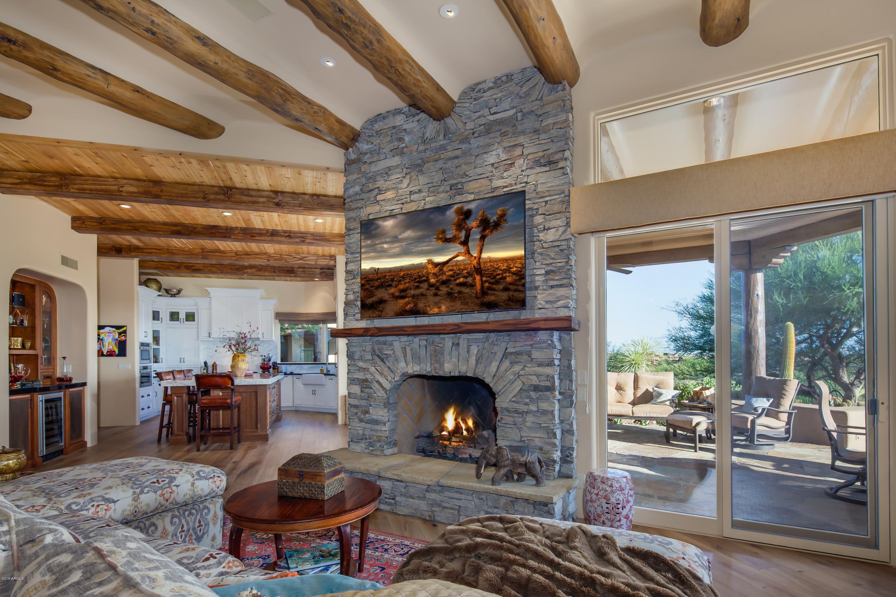 This classic Southwest home exudes with warmth and charm, featuring beautiful beams and vigas and a gated courtyard.  As you step inside the great room, enjoy the inviting, open plan with recent upgrades that incorporate today’s products, such as engineered wood floors, a bright and updated kitchen with Calacatta gold vein marble and black granite counters and top appliances. The cozy, circular dining room features a rotunda ceiling. The master retreat on its own wing is equally charming. Fourth bedroom has custom library cabinetry for a flexible office option. A generous wrap-around south-facing covered patio with Valley views steps gently down to a very sunny pool patio with plenty of space for lounging sun-worshipers. Your guests will rave about the well-appointed two-room casita tucked away in its own private setting with gated entry. Don't miss this very special opportunity!  A Golf or Lifestyle Membership is available through application to the Desert Mountain Club.