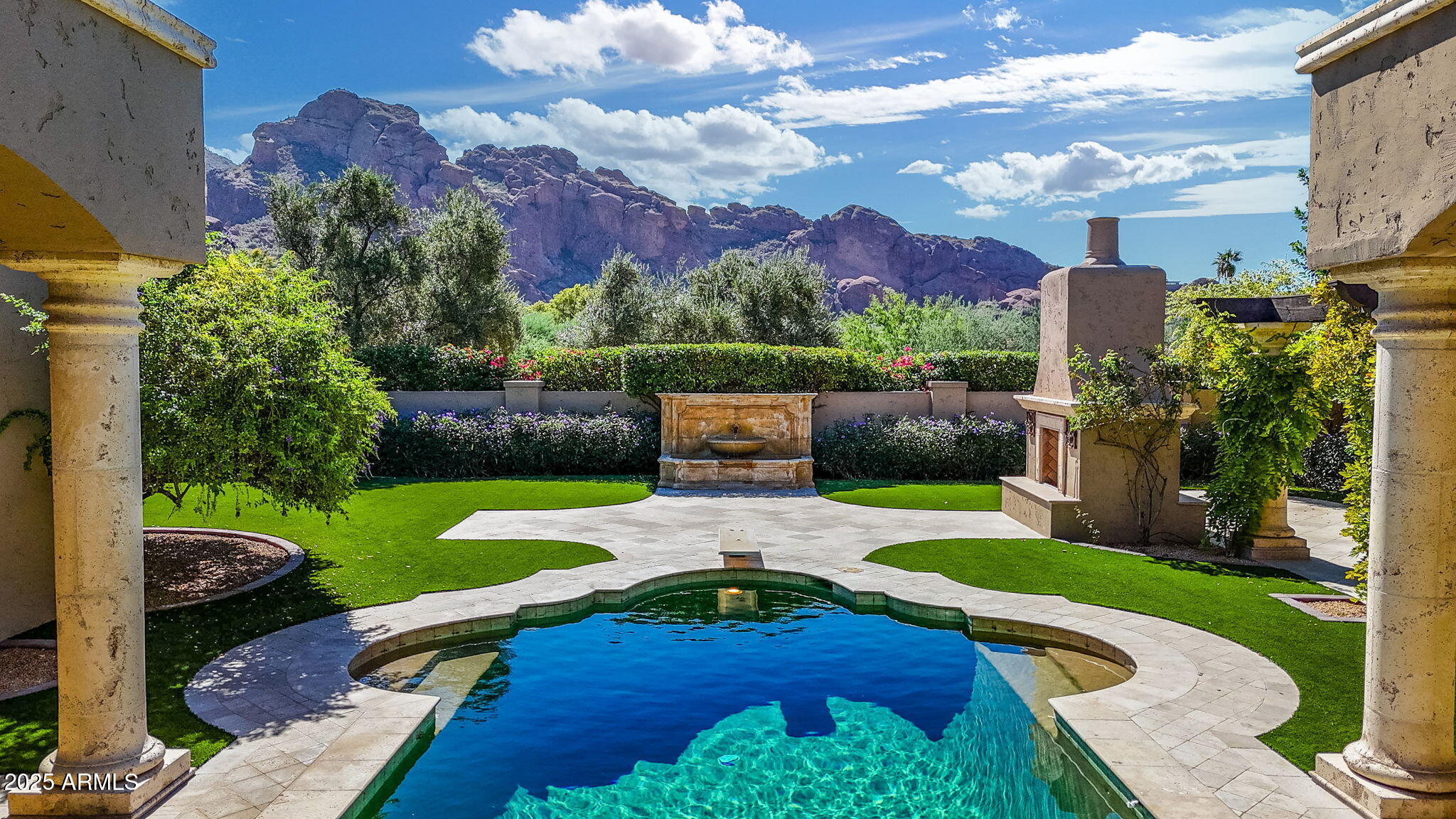 Step into a sanctuary of sunsets & serenity on nearly 1.5 acres. Through expansive glass, Camelback Mountain emerges, bathed in golden rays, while gardens, flowering trees, and verdant landscaping surround you. The courtyard pool is graced by the shimmering dance of light and shadow, casting ethereal reflections onto the ceilings of the surrounding covered walkways. The surrounding horizon is completed by the Phoenix Mountain Preserve & Mummy Mountain, creating sweeping panoramas that anchor this home in both grandeur & tranquility. Throughout the home, artistry is expressed in every detail. Hallways of honed crema Marfil marble lead into main living spaces where Venetian plaster walls soften the light, while the living room's dramatic silver-leaf ceiling shimmers as sunset transforms the space into pure ambience. The kitchen blends European charm with modern function anchored by a striking butcher block island inviting gatherings as much as quiet reflection. From the sink, one looks out across the gardens and luxury aviary, a true farm-to-table experience where fruits, herbs, and vegetables grow steps from the door. State-of-the-art appliances blend seamlessly into this European-inspired design, creating a space equally suited for grand entertaining or intimate mornings at home.  The primary suite unfolds like an Andalusian dream. Beyond custom glass doors through the library, a marriage of timeless European craftsmanship and modern comfort await. Dual retreats open to his and her baths with 19th-century antique sinks and marble. Outside, a heated spa and open-air shower capture the romance of southern Spain offering moments of serenity beneath the desert sky. Expansive his and her custom closets complete this private sanctuary balancing elegance with thoughtful design. The billiard room invites both leisure and refinement, while spacious guest suites, each have a private bath and walk-in closet. Completing the estate is a generous Casita, with its own full kitchen, living space, and bedroom. Perfect for family or long-stay guests, it extends the home's hospitality with independence and warmth. Every corner of this residence, from antique finishes and hidden safes to a laundry room adorned with 19th-century accents, tells a story of thoughtful design. This is not just a home but a masterpiece of light, landscape, and timeless European-inspired design.