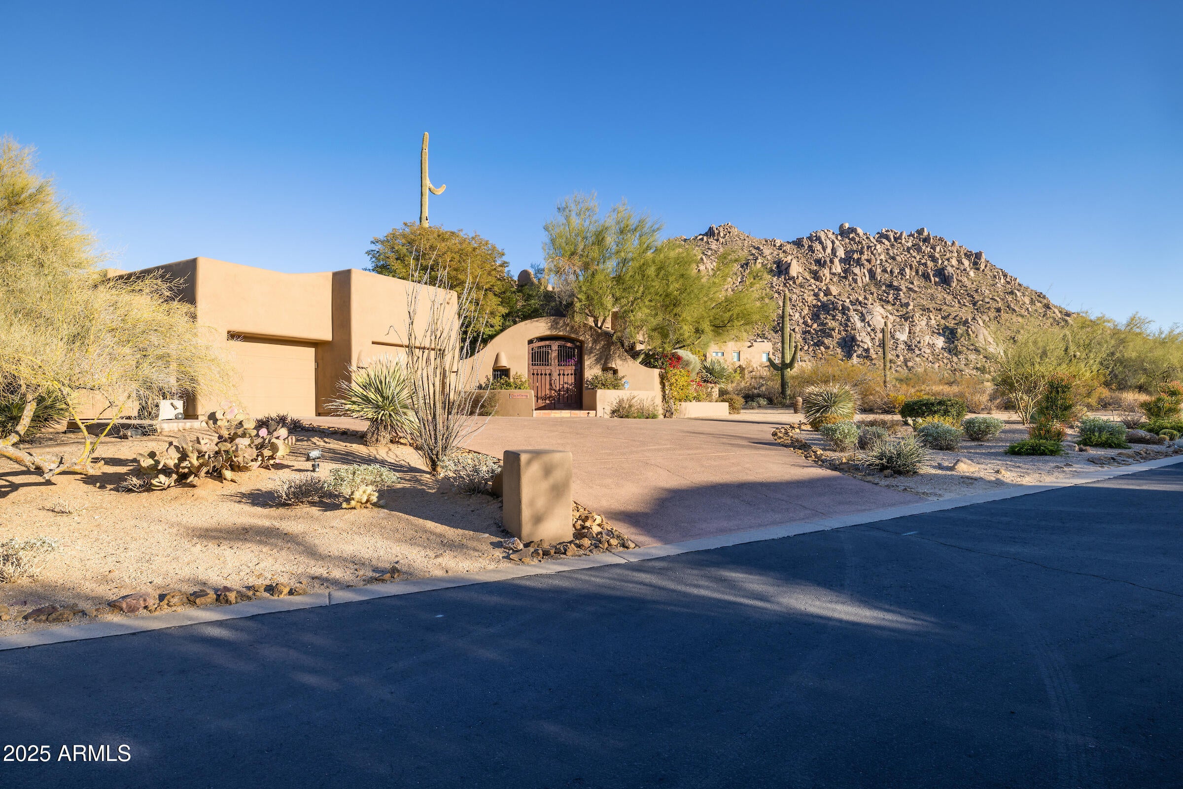 Nestled at the base of Troon Mountain in the prestigious Windy Walk Estates of North Scottsdale, this quietly elegant territorial-style home offers a serene retreat. Boasting 3 bedrooms, 3.5 baths, and a spacious 2-room casita, this property is located in the highly sought-after guard-gated community. The open floor plan features expansive rooms with floor-to-ceiling windows in the great room, inviting natural light to flow throughout. Low-maintenance Saltillo tile graces the main living areas, complemented by authentic Southwestern touches like exposed vigas and intricate Mexican tile. The large eat-in kitchen showcases oak flooring, a SubZero refrigerator, and a Viking stove with a griddle, accompanied by an adjoining wet bar, perfect for entertaining. The primary suite offers a gas fireplace, decorative sinks, and a spacious Jacuzzi tub. Step outside to enjoy breathtaking views of Troon Mountain, Pinnacle Peak, and the nearby golf course. Relax in the private pool and spa, surrounded by lush landscaping, or entertain on the view deck equipped with a built-in grill. The detached casita includes a full kitchen and bath, providing a versatile space for guests or additional living quarters Experience luxury living in this remarkable home that blends Southwestern charm with modern elegance.
