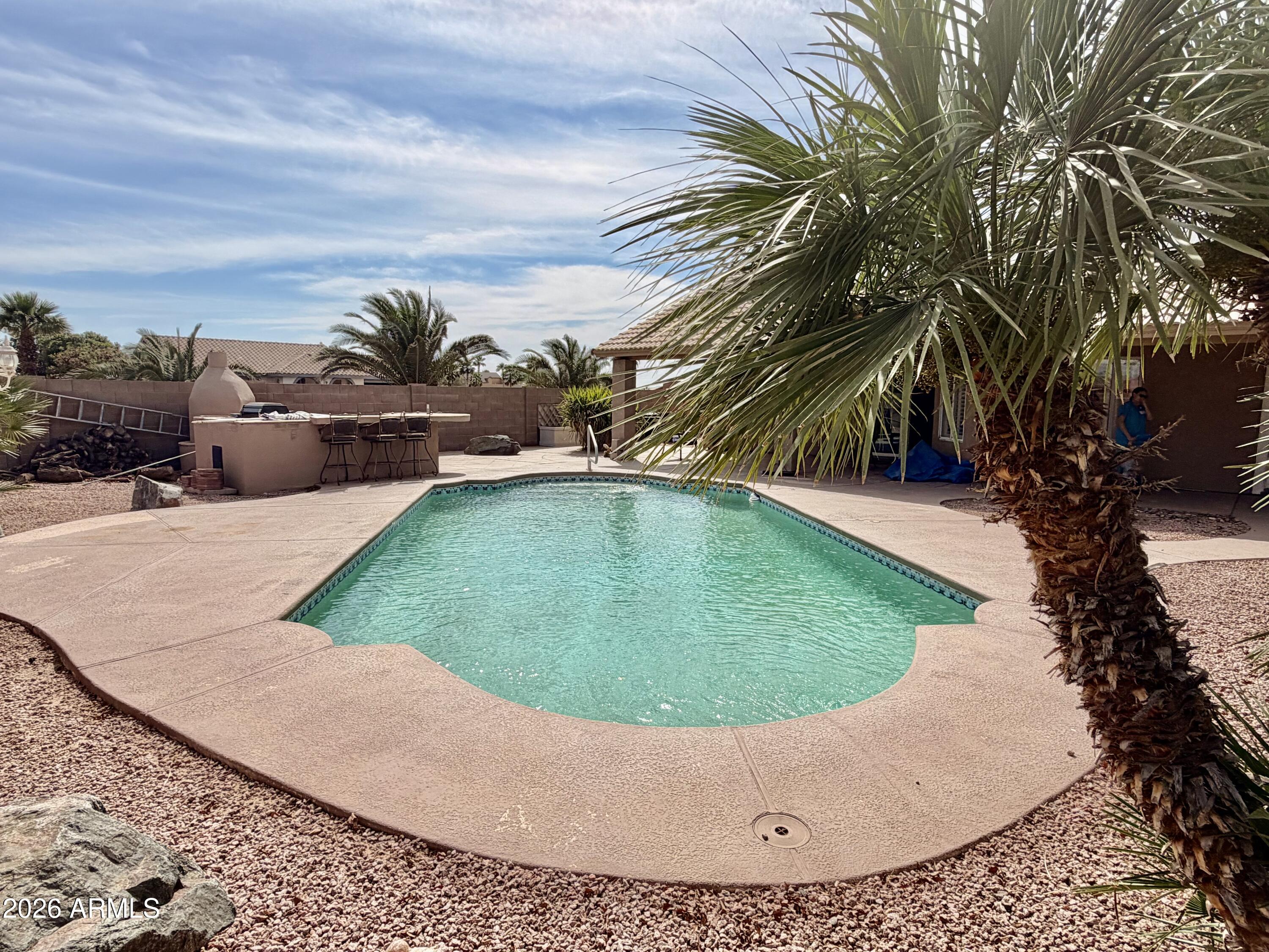 Beautiful single-story home tucked away in a quiet cul-de-sac on an oversized double lot! This property offers incredible space and flexibility, perfect for entertaining, storing toys, or creating your dream backyard oasis. Featuring an RV gate and plenty of room for all your needs. Step inside to a thoughtfully designed layout with generous living spaces, including a versatile flex room ideal for a home office, den, or playroom. The open-concept kitchen flows seamlessly into the family room, complete with a cozy fireplace--perfect for gathering with family and friends. Stylish tile flooring runs throughout the main living areas for both beauty and durability. Step outside to an amazing backyard retreat! Enjoy a sparkling pool, full-length covered patio, and an outdoor kitchen-- perfect for Arizona living and year-round entertaining. With so much space and so many features, this home truly has it all!