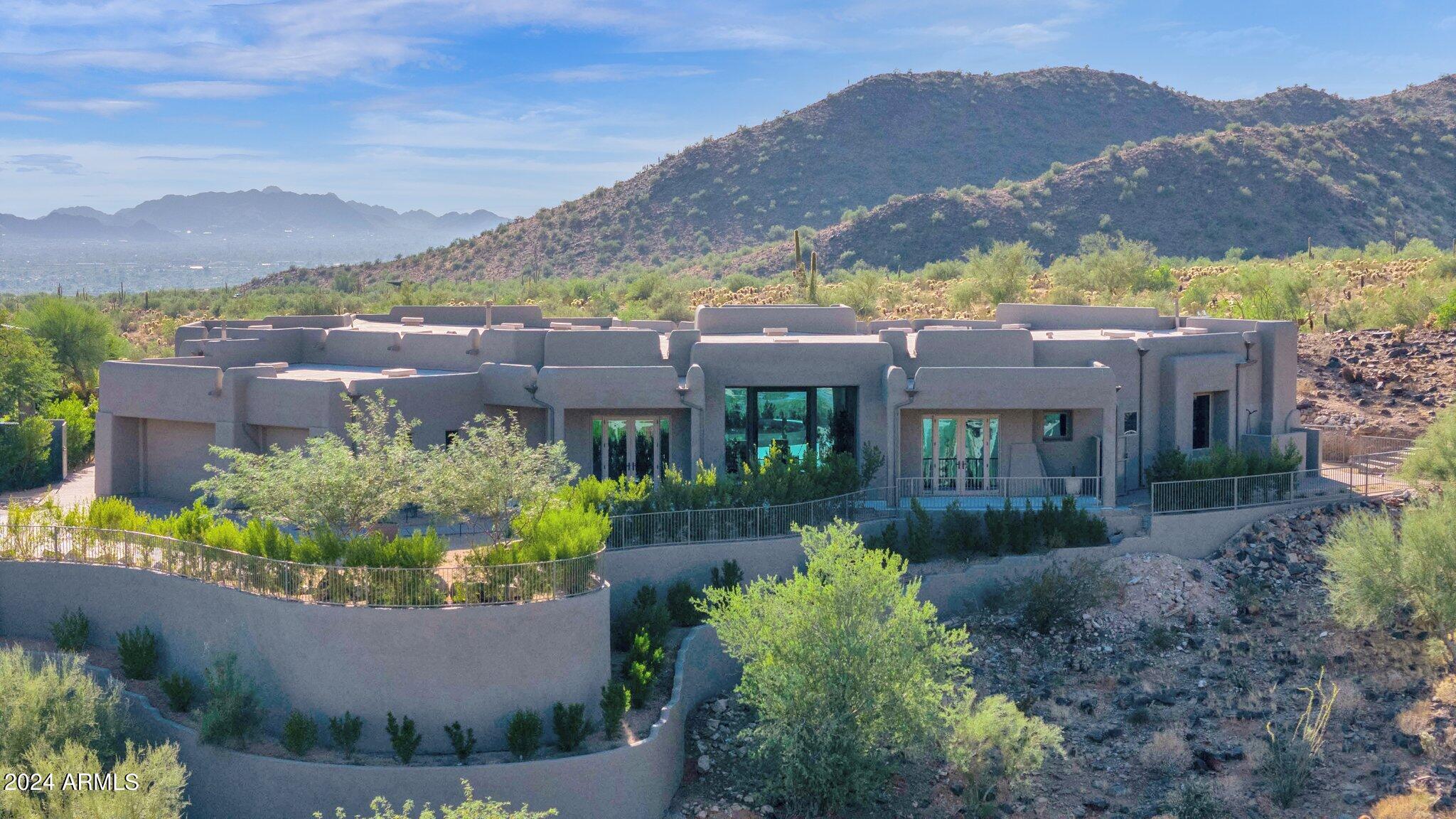 The most remarkable home in Scottsdale Mountain with HUGE camelback and city views is now available. Fully rebuilt with a clean, Modern Organic pallet, this home makes you feel as though you are a part of the mountains. With no neighbors on 3 sides every room of this estate offers jaw dropping vistas.  Step out back and you'll be blown away by the massive pool patio overlooking camelback mountain and the night lights. Inside, see extraordinary spaces and textures that capture the nature around you.  Rift cut white oak cabinets and beautiful Quartzite, Moroccan plaster and unique tile patterns, White Oak Plank floors and floor to ceiling glass. Solid Oak doors and beautiful organic lighting.  You must see this home in person to feel how it captures the romance of living on the mountain.