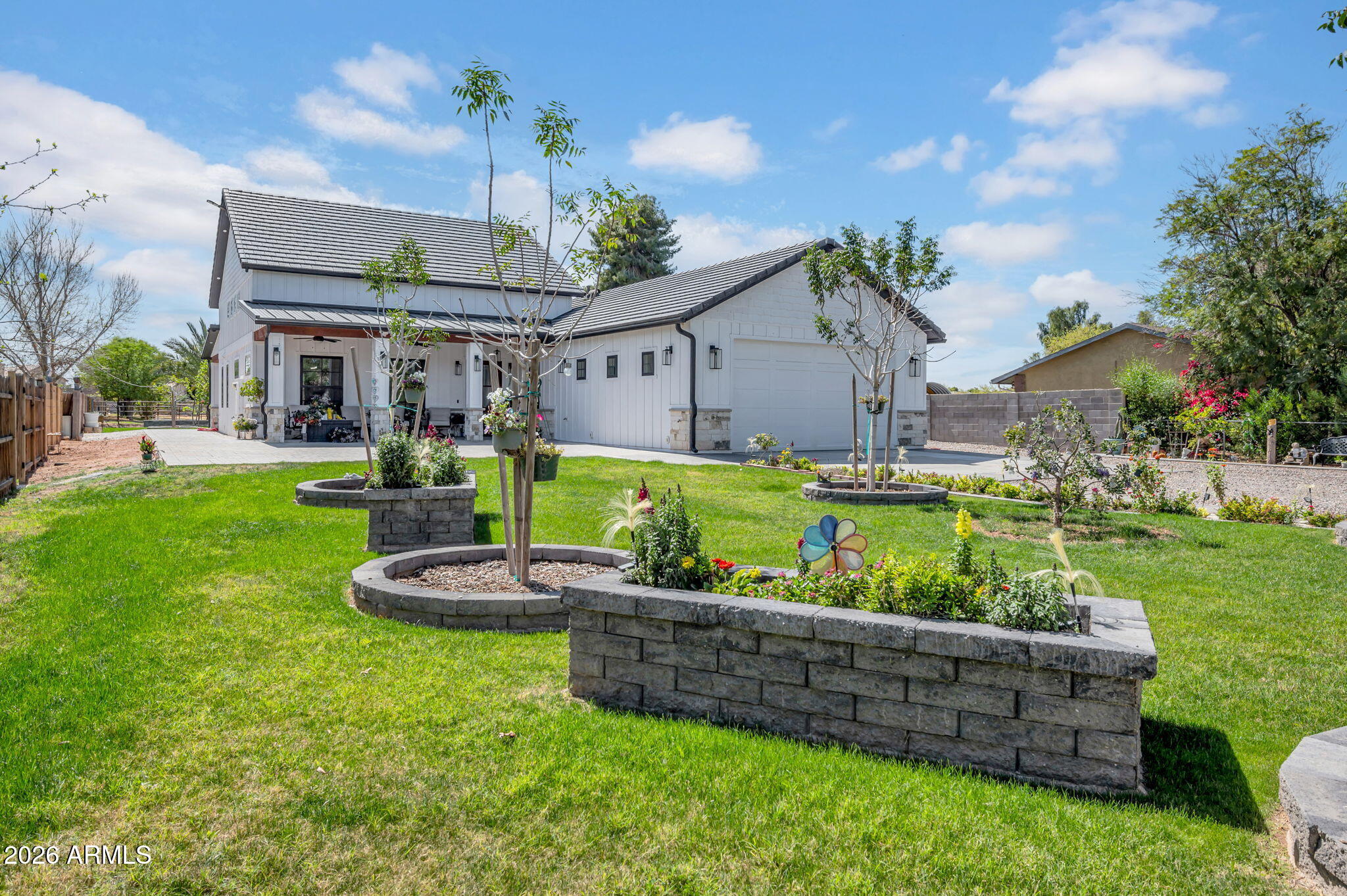 Completed in 2024, this exceptional modern luxury farmhouse blends refined design, thoughtful functionality, and wide-open space, offering nearly 2,300 sf of beautifully crafted living space with 2 bedrooms and 2 bathrooms. Striking curb appeal welcomes you with classic board-and-batten architecture, crisp black accents, and an expansive covered front and back patio designed for inviting indoor-outdoor living, featuring rich wood ceilings and elegant stone columns.
Inside, the home showcases a bright and inviting open-concept floor plan highlighted by a dramatic 25-foot ceiling in the great room, creating an impressive yet comfortable gathering space perfect for everyday living and entertaining. The stylish chef's kitchen features quartz countertops, abundant cabinetry, two large sinks, and a spacious walk-in pantry/coffee bar, combining sophisticated design with practical convenience.
The expansive primary suite offers a peaceful retreat with a generous walk-in closet and a beautifully designed spa-like bathroom featuring an extra-large clawfoot soaking tub and rain shower head. Convenient access through the laundry room leads to the fully air-conditioned garage. A spacious secondary bedroom provides an ideal guest suite or flexible living space.
Built with quality, efficiency, and modern living in mind, the home includes two high-efficiency AC units, a tankless water heater, water softener, spray foam insulation throughout, insulated garage doors, epoxy garage flooring, and a substantial electrical panel with additional capacity for future expansion. The climate-controlled garage features a 10' garage door to accommodate larger vehicles and is also equipped with EV charging capability. Bring your RV as there is a hookup and drain conveniently located on the far side of the garage.
The grounds are beautifully enhanced with irrigation rights and mature landscaping, including a variety of fruit trees such as lemon, pear, orange, pomegranate, mulberry, plum, and guava, along with vibrant roses and a Silver Laurel.
With ample land and space for horses, cows, chickens, and other livestock, the property offers the rare opportunity to enjoy a luxury farmhouse lifestyle with room to create your own mini ranch or hobby farm while still enjoying the comfort of a newly built home, with additional space and flexibility to expand or add on if desired.
Enjoy a short walk to the canal with miles of walking and biking paths, and THE CONVENIENCE OF BEING WALKABLE TO THE GILBERT HERITAGE DISTRICT AND DOWNTOWN GILBERT offering some of the area's most popular restaurants, shops, and entertainment while still enjoying privacy and open space. Blending timeless farmhouse charm with modern luxury, thoughtful amenities, and room to roam, this newly completed property offers a truly unique living experience.