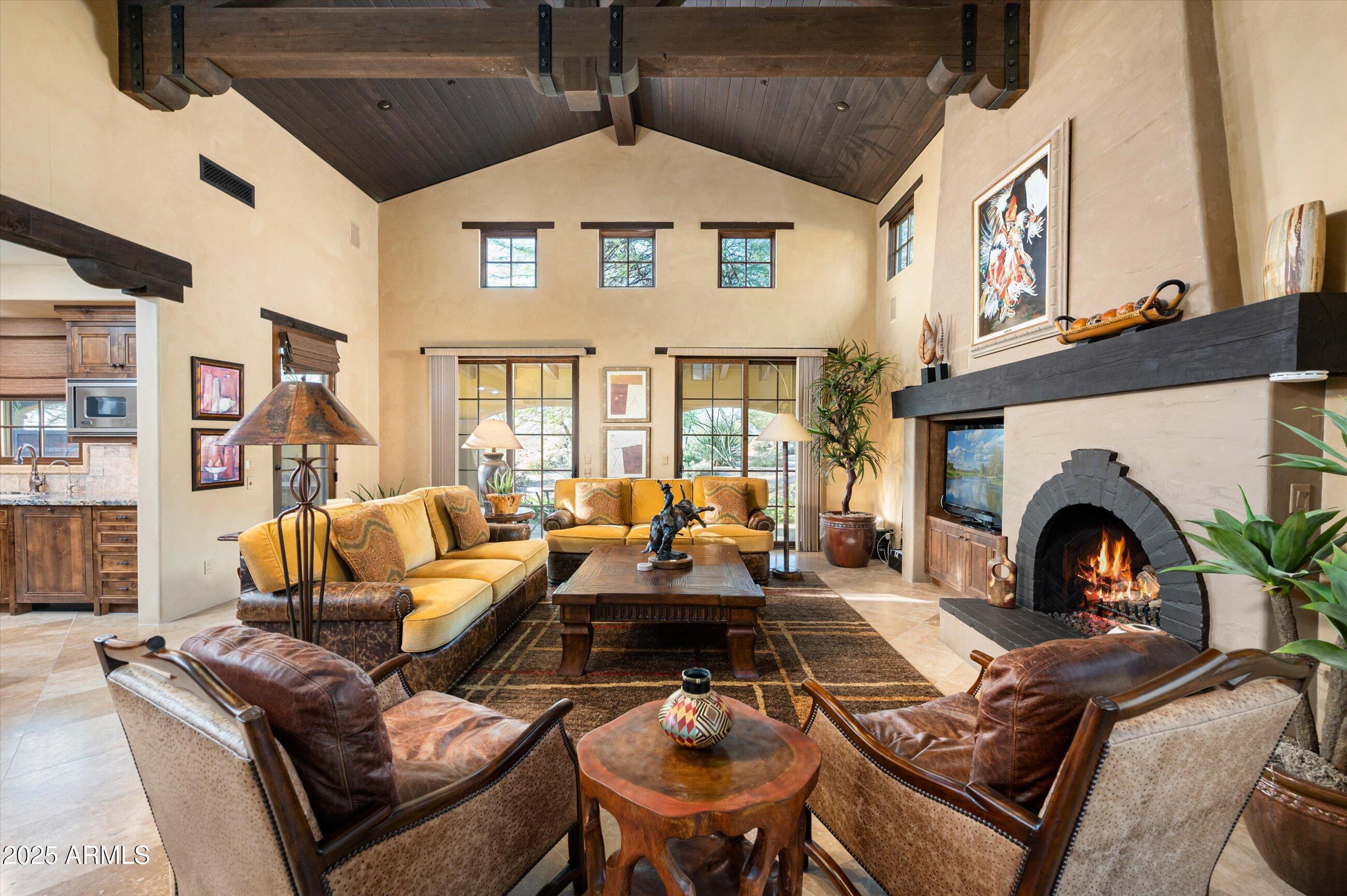 Desert Mountain Golf Membership is available. This exceptional west-facing residence features a welcoming courtyard entry complete with an outdoor fireplace and water feature. The grand great room showcases impressive, beamed ceiling details and offers an ideal space for entertaining. The gourmet kitchen is equipped with granite countertops, elegant tile backsplash, an oversized island, premium Viking appliances, and a walk-in pantry. The spacious primary suite includes a fireplace, access to the patio with a hot tub, dual sinks in the primary bath, a separate tub and shower, and a generous walk-in closet. There is a separate outdoor entrance to the upstairs guest casita, which overlooks the front entry. Offered Turnkey with few exceptions.