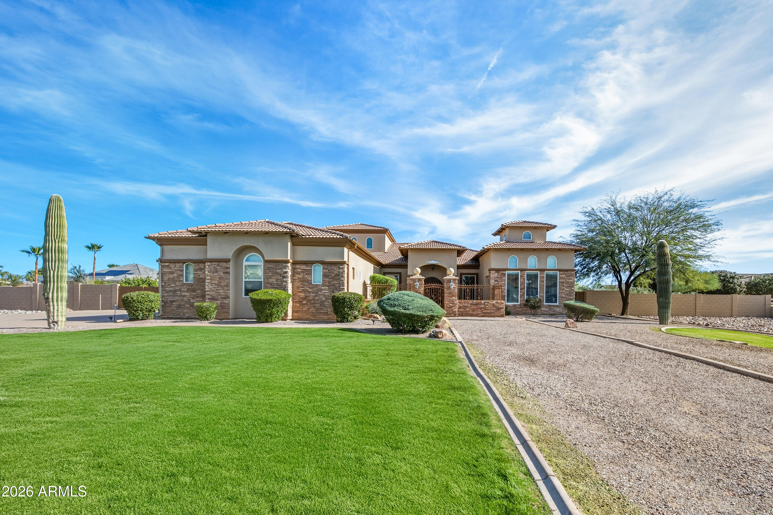 Don't miss the walkthrough video! A truly exceptional custom home in the heart of Sonoqui Creek Ranch, set on a premium corner lot just under an acre with standout curb appeal. Opportunities like this are rare. Lightly lived in and owned by the original owner, this residence has been used only weeks out of the year and shows like a model.

Designed with space and sophistication in mind, the home offers four spacious ensuite bedrooms, each with its own walk-in closet, along with soaring 12-foot ceilings throughout. The impressive vaulted ceiling over the kitchen creates an immediate sense of scale and elegance. The expansive yet refined floor plan features a welcoming living room with formal dining and dry bar, complemented by an oversized family room centered around a gas fireplace— ideal for both everyday living and elevated entertaining. The gourmet kitchen is a true showpiece, featuring abundant cabinetry, granite countertops, cooktop, wall oven and microwave, and a large walk-in pantry. A versatile bonus space near the primary suite provides the perfect setting for a private office, fitness room, or additional lounge. The primary retreat is generous and luxurious, offering a spacious bedroom and spa-inspired bath with dual vanities, soaking tub, separate tiled shower, and a large walk-in closet. Outdoor living is exceptional with an expansive east-facing covered patio providing excellent shade and ample entertaining space, a large sparkling pool with spa, and beautifully established olive trees and fruit-bearing citrus. There is plenty of room to add an RV garage or casita, enhancing the property's long-term flexibility and value. Parking is abundant with a three-car garage, extended driveway, and RV gate. This rare Sonoqui Creek Ranch offering delivers privacy, space, and refined desert living and must be seen in person to be fully appreciated.