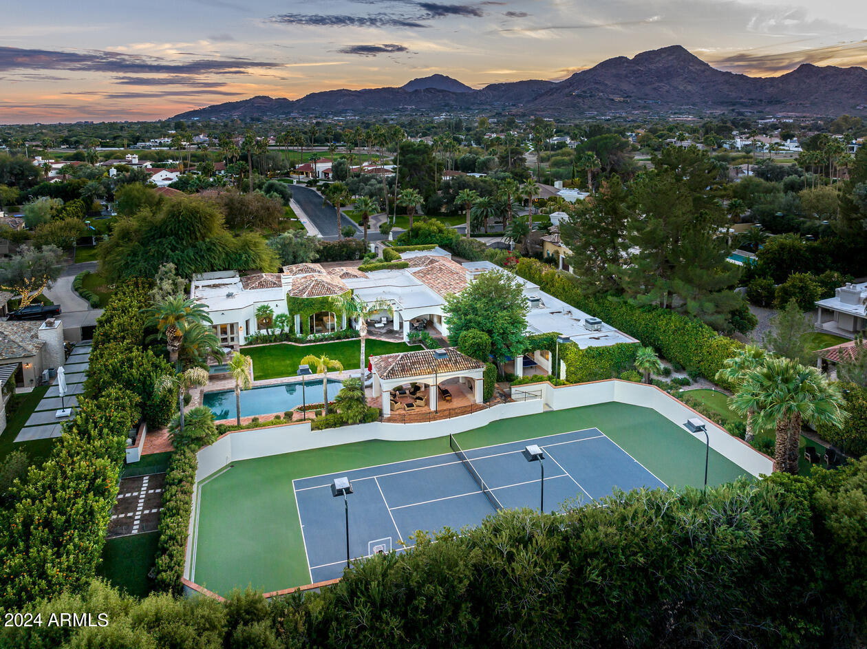 Drive up to this fabulous 1.2 acre GATED estate and be impressed!! The approach is a statement in itself- This 7,647 single level property built by Cal Christiansen is surrounded by  very high orange trees. The elegant tops of the perimeter walls are finished with clay tiles, and the long driveway is brick pavers . The home and attached guest home were extensively RENOVATED between 2014 to 2023. The grounds include a lighted A+ professional TENNIS COURT, viewing ramada, large rectangular pool + spa, plus an EXTENSIVE GRASS YARD. This charming home is warm + inviting with  attention to detail. It also has a billiard rm, paneled library, a large master with separate  sitting rm and 2 spacious closets, kitchen opening to the family rm with soaring ceilings + a distinctive wine wall w/ ladder