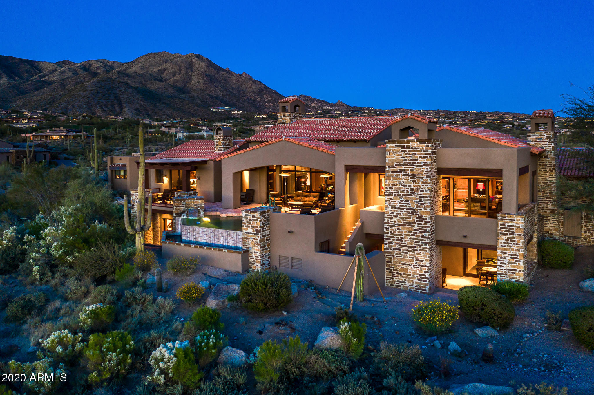 Recently featured on the Fox Business News ''Mansion Global'' TV show.   One of a kind Lee Hutchinson designed home with ''old world'' finishes and uniqueness not seen in today's designs and new builds.   Spectacular sunset, city and mountain views with multiple outdoor living spaces to enjoy the high desert views.  Direct access from the garage to the main level which has all of the living areas central to the daily home activities.  Kitchen, family room, master suite, 2 additional bedroom suites, owners office and the main entertainment living area with bar.  Take the elevator or staircase to the lower level and you find a 2nd master suite, additional bedroom/exercise room, wine cellar, 9 seat theatre,  steam and  sauna rooms. a multi purpose family room with full bar and more.  See for yourself the quality of "old world" finishes difficult to find in todays contemporary "cold" finishes.