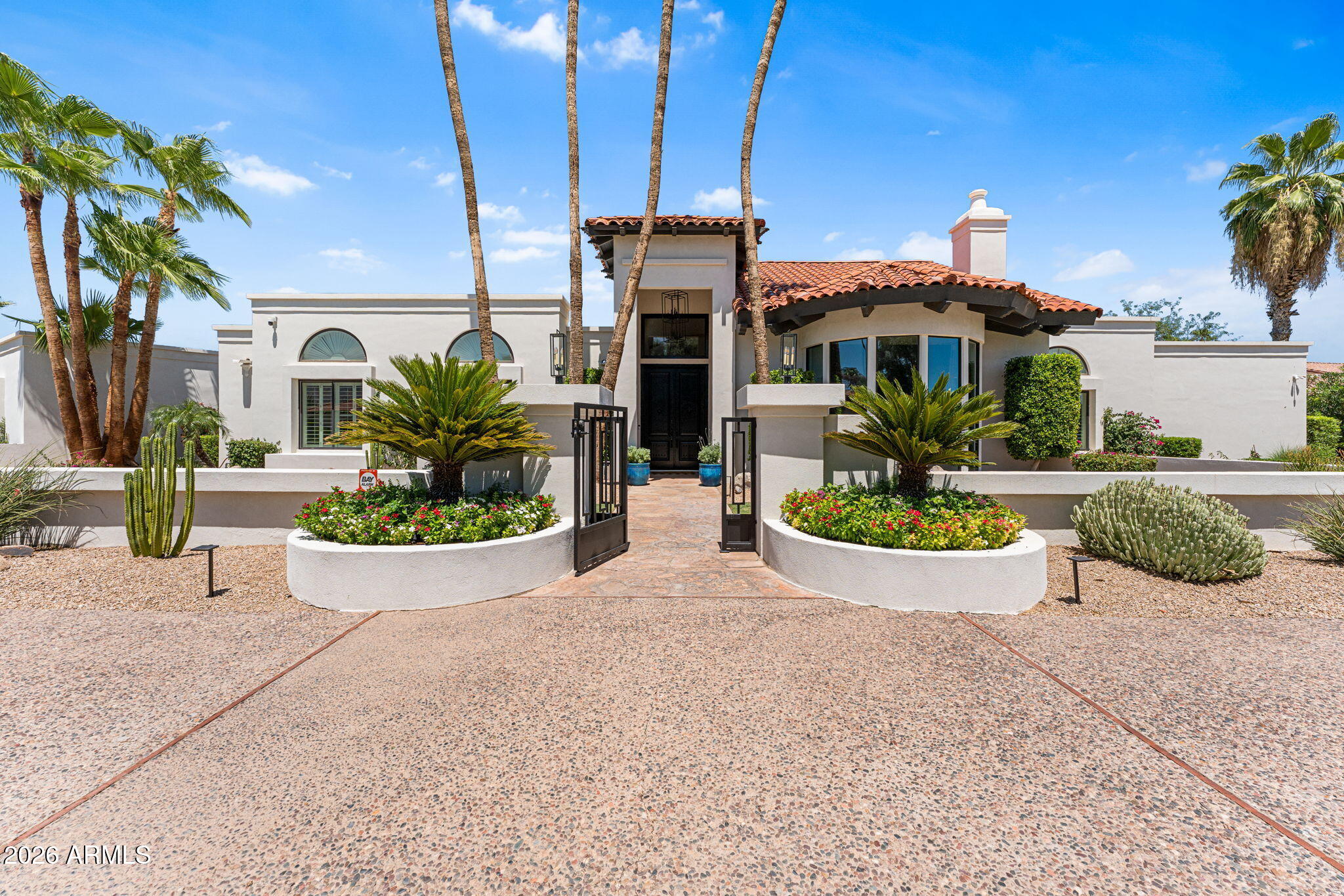 Camelback Country Estates -Santa Barbara-dream estate tucked in one of Paradise Valley's quiet enclaves. This 5 bed, 5.5 bath residence offers soaring beamed ceilings, French oak floors, and a gracious open layout designed for effortless living and entertaining. The chef's kitchen features SS appliances, dual refrigerator/freezer, double ovens, and a gas cooktop. The serene primary includes a fireplace sitting area, spa-like bath, dual walk-in closets, and an outdoor spa just steps away. All secondary bedrooms are ensuite with recently updated baths. Attached Casita, lush grounds include a heated saltwater diving pool, separate spa, poolside ramada, putting green, sport court area, batting setup, and lush landscaping. 3-car garage with overhead storage & charging station. 3 C's School Area