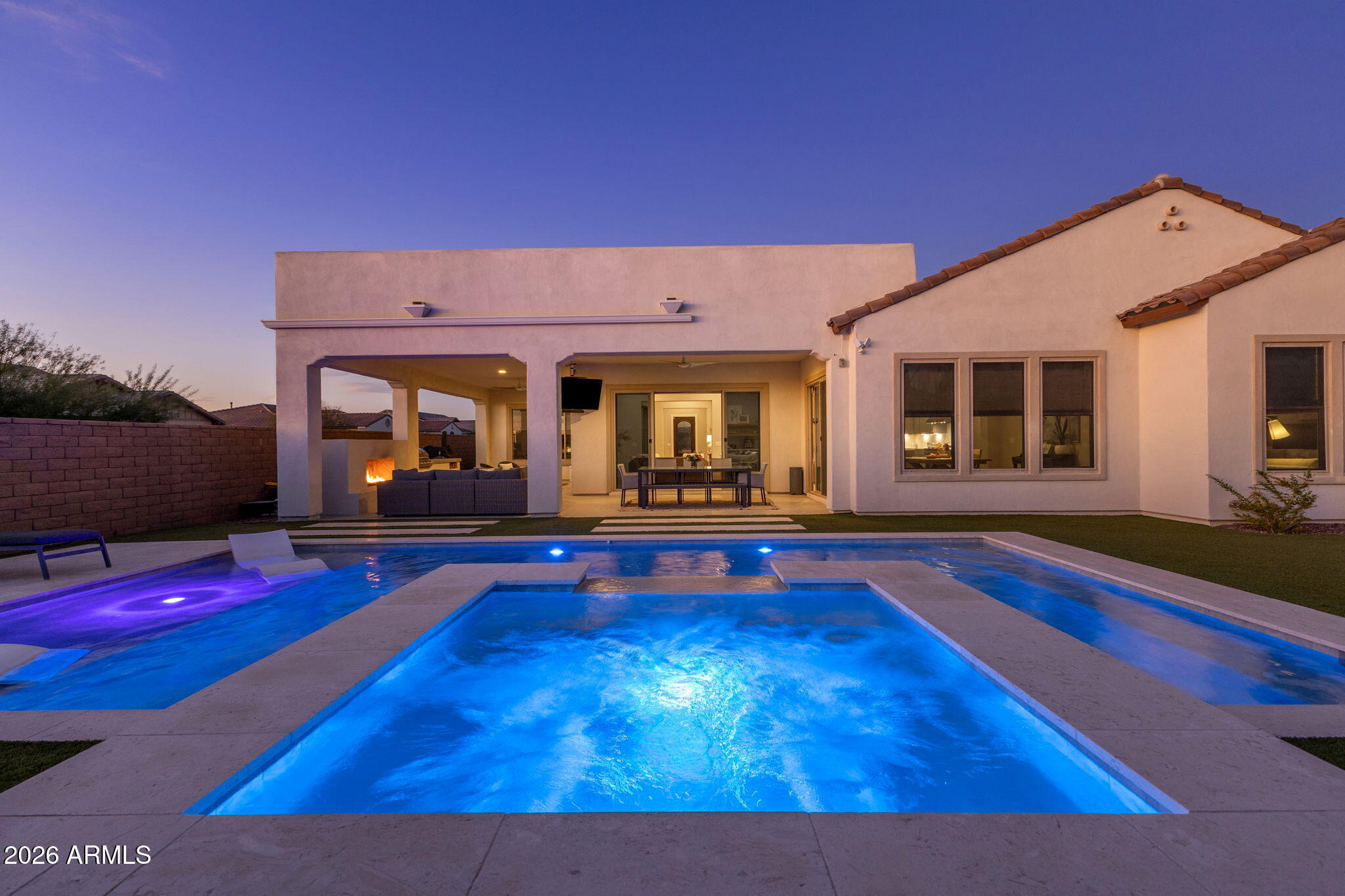 Tucked behind the gates of Palomino Estates, is a refined desert sanctuary where luxury, privacy, and timeless elements converge. The home makes a striking first impression with its custom iron and glass entry door and a sense of arrival that immediately sets the tone for the exceptional living experience within.  Entry hall opens to the gathering room, dining space and kitchen with lots of natural light and a large sliding door that provides sought after indoor/outdoor living. The kitchen is a true showpiece, thoughtfully crafted for the culinary enthusiast and entertainer, featuring high end KitchenAid appliances: 48'' refrigerator/freezer, double dishwashers, gas range, built-in microwave/wall oven. Custom cabinetry and a massive executive island with generous seating for gathering. .  A dedicated study adds both style and function, enhanced by a custom sliding iron and glass door and a striking wall detail that elevates the space. Designed to be spacious and versatile, it easily accommodates work, study, and entertainment, offering flexibility to suit your lifestyle.  A thoughtfully designed split floor plan provides privacy for guests, with well-appointed guest bedrooms and a guest bath tucked away from the primary suite. A stylish powder room adds convenience for visitors, while a large laundry room offers exceptional functionality with ample space for storage, organization, or additional appliances.  The primary suite is a true retreat, offering a spacious bedroom with serene backyard views. The primary bath was customized, featuring a large walk-in shower, a luxurious freestanding tub, dual vanities, and an expansive walk-in closet.  Step outside and discover a resort-style backyard oasis designed for year-round enjoyment. The stunning pool with baja ledge invites leisurely days under the Arizona sun, while a large spa with a cascading waterfall creates a soothing ambiance for evenings beneath the stars. A gas fireplace adds warmth and drama, making the outdoor space just as inviting on cooler nights. The expansive covered patio showcases tile flooring and provides generous room for dining and lounging, complemented by an outdoor BBQ island with gas pizza oven ideal for hosting unforgettable gatherings. A lush turf lawn adds a vibrant, low-maintenance contrast to the surrounding desert landscape, completing this exceptional outdoor retreat.  Convenient location to shopping, schools, outdoor recreation.