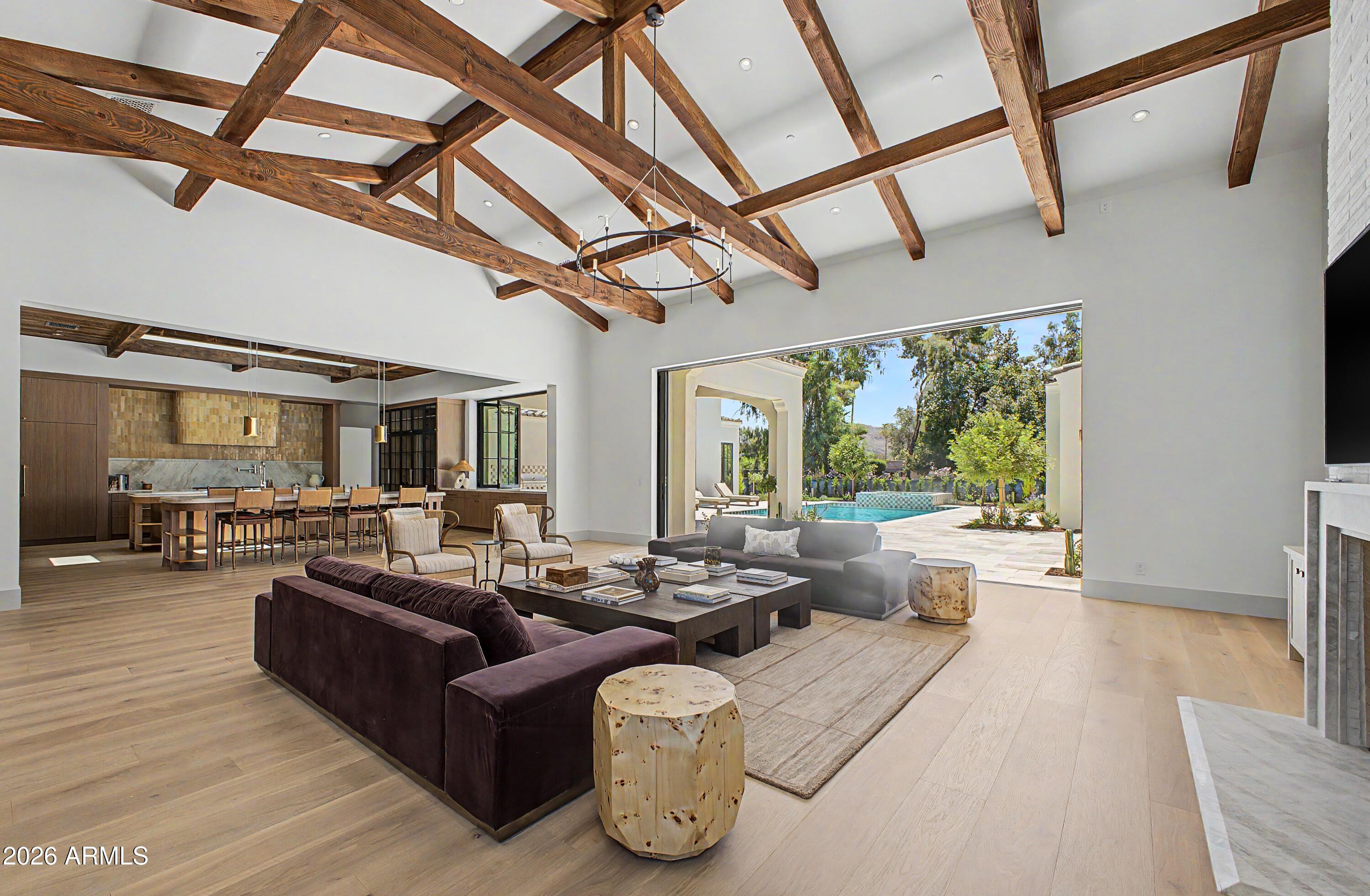 NEW CONSTRUCTION has arrived in Paradise Valley unlike anything currently on the market. Defined by warmth, depth, natural materials, and a level of comfort rarely achieved in new construction, this residence reflects a subtle sophistication felt intuitively the moment you enter. Thoughtful construction standards include 2x6 sound-insulated walls, solid 8-foot doors, 10-inch wide-plank oak flooring, curated natural stone and tile selections, honed Taj Mahal quartzite double islands, matching Taj Mahal mitered stone fireplace detailing, and 8-inch cove base--all contributing to a cohesive sensory experience created through an extraordinary collaboration of architecture, interior design, and craftsmanship.  Situated on 1.18 acres with no HOA in the coveted Camelback Country Club - Cherokee Elementary Corridor, this single-level estate seamlessly integrates indoor and outdoor Arizona living through soaring 17-foot exposed wood-beam ceilings and fully retractable walls of glass recessing into pocketed walls opening to a covered outdoor living pavilion overlooking the Presidential pool and spa. The double-Taj Mahal island chef's kitchen features Sub-Zero and Wolf appliances, a fully equipped butler's pantry-dirty kitchen with additional Wolf ovens and Cove dishwasher, and a dining room anchored by dual Sub-Zero wine towers. A sideboard allows guests to help themselves with crushed ice and beverage drawers, in addition to a large sit-up continuous slab pass-through window to the wood-clad covered BBQ Pavilion. All bedrooms are ensuite. Primary wing is split with private wellness courtyard. Guest parking in front, with privately gated resident's paved driveway to the side entry auto court, with 4 car garage expandable to 8. Even the laundry room has been elevated with brick floor, Burdette cabinets and mountain views! 
An award-winning collaboration by Tiara Sun Development, Jim Blochberger, and Evon Fig Interiors.
Designed as a fully integrated living environment, the home balances architectural presence with everyday livability. Wood-beam ceilings, handcrafted finishes, curated lighting, and a layered natural material palette create warmth, continuity, and enduring timelessness throughout.
This is not simply a home--it is designed to restore, perform, and endure. Rooted in a philosophy that views architecture as a cohesive living system calibrated to human biology and well-being, the residence reflects a forward-thinking approach to luxury centered on wellness, performance, livability, and enduring design. The result is more than shelter--it is a home designed to enhance how life is experienced every day. ORGANIC-LUXE" has arrived in Paradise Valley.
See full specification sheet. Disclosure: Listing agents hold ownership interest.