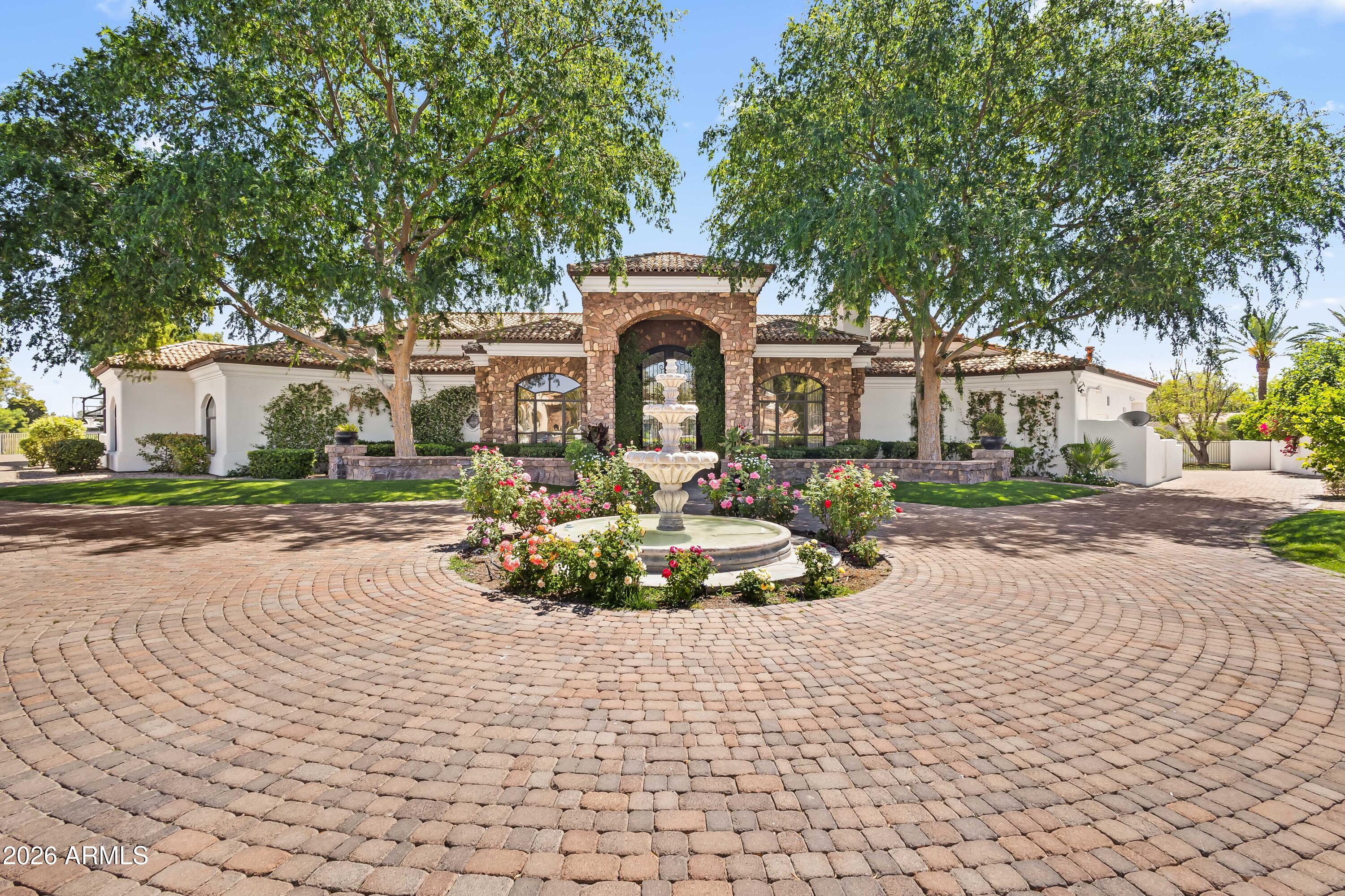 Gated 1-acre lot in the exclusive enclave of Ironwood at Camelback Country Club. With only nine homes in this quiet, highly sought-after Paradise Valley community, this estate offers exceptional privacy, luxury, and direct access to the 7th hole. The main residence showcases timeless architectural details including soaring ceilings, arched entryways, paneled walls, and multiple gas fireplaces. The well-designed layout features formal living and dining rooms, along with a dedicated study complete with built-in shelving. Designed for both everyday living and elevated entertaining, the open-concept family room flows seamlessly into the chef's kitchen, appointed with premium Wolf and Sub-Zero appliances, a butcher block island, breakfast nook, and walk-in pantry. The primary suite is a private retreat with direct outdoor access, a cozy sitting area with fireplace, and a spa-inspired bath featuring dual vanities, a freestanding soaking tub, oversized walk-in shower, and a custom walk-in closet with integrated laundry. The backyard is ideal for year-round entertaining, offering a heated pool and spa, multiple covered patios, an exterior fireplace, and fire pit with ample space to relax and gather. A fully equipped guest house enhances the property with its own kitchen, game room, living area, and expansive movie theater--perfect for multi-generational living or extended stays. Additional highlights include a 5-car garage and a premier location just minutes from Arizona's top resorts, fine dining, shopping, and entertainment. A rare opportunity to own a luxury golf course property in one of Paradise Valley's most intimate and desirable communities.