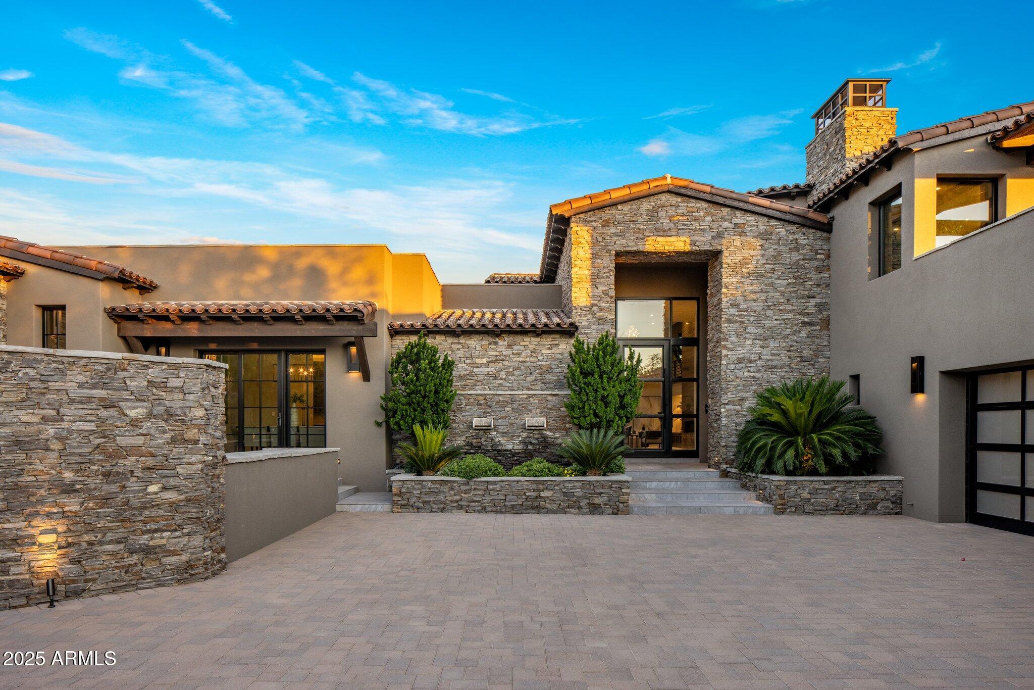 IMMEDIATE GOLF MEMBERSHIP INCLUDED to one of Scottsdale's most prestigious private clubs!  From the moment you pull up to this stunning desert contemporary retreat you will feel how special it is, from its beautiful, stacked stone walls, to its rich wood details, and clean lined glass garage doors.  As you step inside your excitement will grow at the open concept floorplan with true indoor-outdoor living and over the top luxury finishes and amenities.  The great room is centered around a stunning 2 story stone fireplace and is open to the gourmet kitchen with side-by-side Subzero refrigerator and freezer, chef style range, double ovens, two dishwashers, built-in coffee bar and of course the impressive island complete with a family style gathering table. The entertainment hub of the house continues into the impressive wrap around wet bar with refrigerator and icemaker and into the dining room and stunning wine room.  And of course there is a private theater with candy bar!  Even more impressive is the game room complete with its own expansive wet bar with refrigerator, wine refrigerator, icemaker, dishwasher and its own private fireplace, distinctive bathroom, and walkout patio.  The owner's suite is calming with warm wood floors, a textured stone fireplace, designer lighting, and a spa like bathroom with a double vanity with hidden TV, beautiful slab walls, a relaxing soaking tub, multiheaded shower, and an expansive walk-in closet with its own laundry.  Guests will feel just as pampered in any of the 3 guest suites, from the Jr. Owners suite with fireplace, a private patio, and bathroom complete with a double vanity, soaking tub, walk-in multi head shower, and a walk-in closet.  The second wing consists of 2 oversized bedrooms and a shared Jack and Jill bathroom with a double vanity and a tasteful walk-in shower.   The secluded office could easily be a 5th guest suite and features stunning Pinnacle Peak and city light views, warm wood floors, a stacked stone fireplace, beautiful bult-in cabinetry including murphy bed, as well as a private patio.  The outdoors are taken to the extreme starting with the front courtyard centered on Pinnacle Peak with a tranquil water feature and a built-in fireplace,  continuing on to the seamless transition from the indoors out to the stunning backyard with golf course, mountain and city light views as well as ample sunning decks and multiple covered patios including the outdoor family room with a fireplace, built-in heaters, sunscreen and a big screen TV.  The private backyard is centered around a stunning zero edge pool with fountains and a firewall, a splash pool, as well as a hot tub located just steps from the master bedroom with its own fire wall.  Even your pups will have their own special place to hang on the turf lawn.  The awesomeness of the outdoors continues to the amazing outdoor kitchen complete with a built-in BBQ, smoker, kegerator, big screen TV, pizza oven and fire table.  The piece de resistance is the expansive entertainment deck with amazing views from every angle including watching your friends play golf on the lush 9th fairway.  Owning in Desert Highlands has its privileges; this amazing home comes with an immediate Full Golf Membership to Desert Highlands where you will enjoy an 18 hole Signature Jack Nicklaus' Golf Course, an 18 hole par 42 putting course designed by Gary Panks, 13 perfectly groomed tennis courts (grass, clay, & hard courts) as well as pickle ball courts, a state of the art fitness center, multiple dining options, and 24 hr guard gated security!