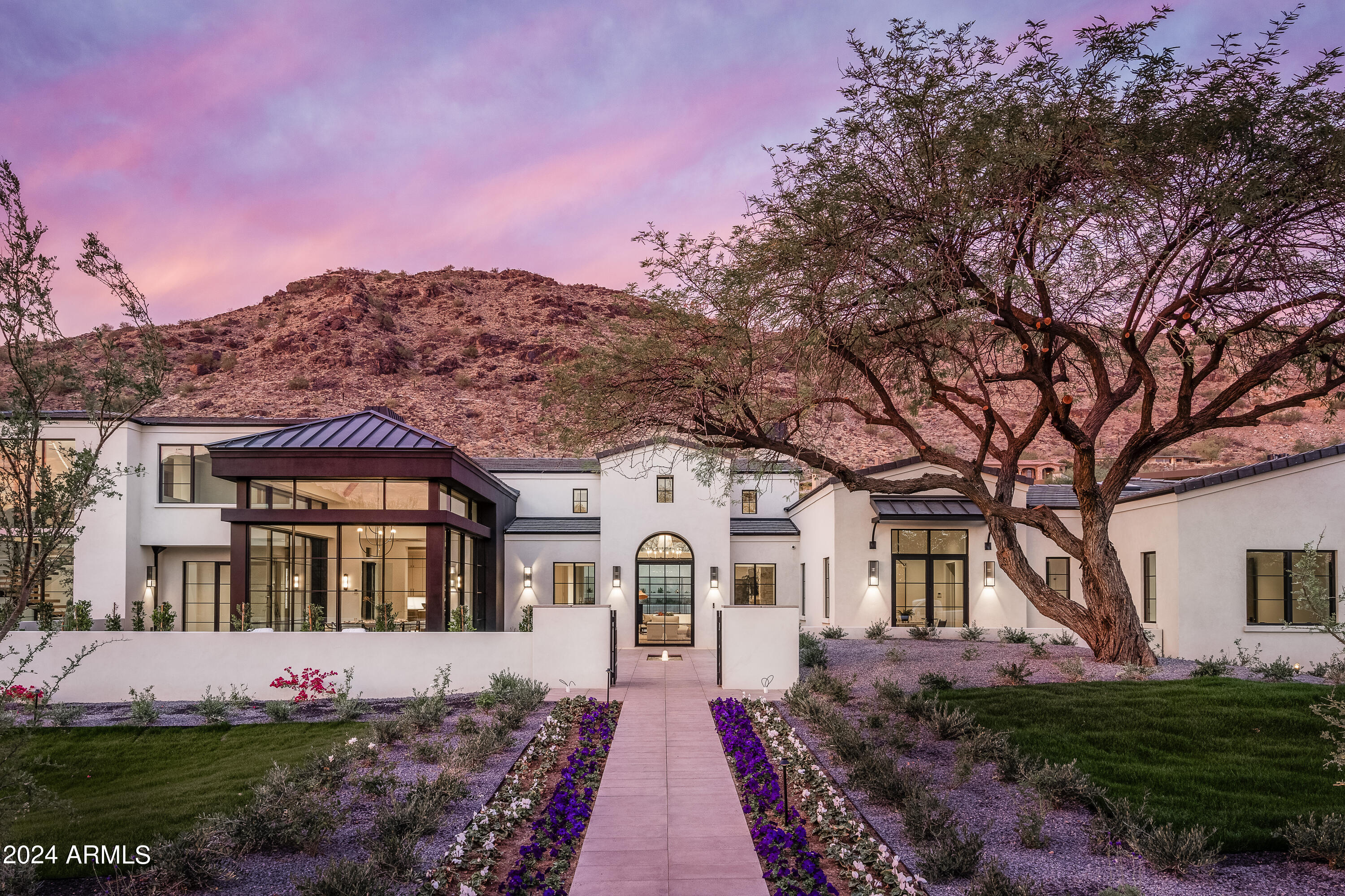 JUST NOW COMPLETED and ready for a lucky Buyer, this brand new masterpiece of architecture and design is tucked into a private cul de sac with exceptional unobstructed views of Mummy and Camelback Mountains. The dream team of Temac Development, Candelaria Design Group, interiors from Iconic by Kaitlyn Wolfe and landscape by Refined Gardens have created this spectacular new modern Mediterranean home. The home features impeccable construction, materials and finishes, open living areas that flow seamlessly from inside to outdoors and dramatic and unique spaces. The public kitchen is supported by a full back kitchen and the impressive dining pavilion has stacking doors on all sides with stunning views. The home is private and intimate while capturing sweeping mountain views. See More tab..... The two master suites are each incredible along with a 3 bedroom guest wing with its own sitting room

In addition to the 5 en-suite bedrooms, there is a full en-suite office and separate media/entertaining room. The fully air conditioned 4 car garage is designed for lifts to accommodate 2 additional cars, for a total of 6 cars, and features a great workshop space in the middle. Construction quality that is never seen including ICF block and concrete construction and outstanding windows and doors from premier maker Awake Windows. A huge mature tree welcomes you while huge views of both mountains flank the home. There is nothing of this caliber on the market and you will be truly inspired by this epic property.