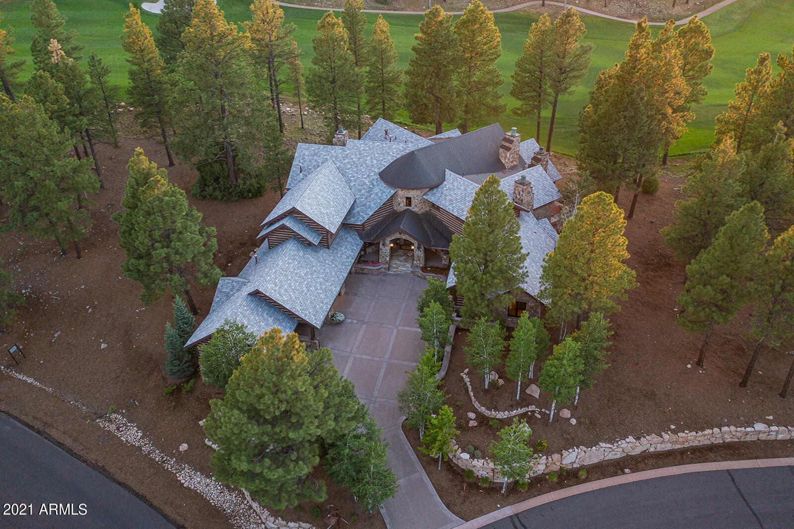 This mountain home is the definition of Rustic Elegance. As you enter the grand foyer, you are drawn to the accenting water feature. Beyond the serenity of the flowing water, the views will take your breath away. The foyer flows into the great room featuring soaring ceilings and an extravagant floor-to-ceiling stone fireplace not to mention a magnificent covered patio with views of the San Francisco Peaks, and overlooking the 18th fairway and nearby lake. The patio is complete with built in surround sound, a fireplace, and a built-in BBQ. Nestled off of the great room, is a full-service sunken wet bar complete with granite countertops, a beverage refrigerator, and bar seating. Adjacent to the great room is the kitchen. This kitchen is a chef's dream complete with professional-grade Wolf Sub-Zero appliances, a large island, breakfast bar, double oven with 6 burner range and griddle, 2 dishwashers, a warming drawer and granite countertops. Just off the kitchen is a dining area, an office space and a large butler's pantry perfectly situated between the kitchen and dining area including an additional refrigerator and dishwasher. Just around from the butler's pantry is an expansive temperature-controlled wine cellar. 
Located on the main level, the master suite features a fireplace, another laundry room and a private spiral staircase to the upper level. The master suite has a private exit to the open back patio complete with a hot tub and views of the San Francisco Peaks, golf course and lake. The luxurious master bath is heightened with men's and ladies' vanities separated by men's and ladies water closets including a bidet and urinal. There are 3 individual showers including a steam shower and a towel warming drawer. This extravagant master bath also includes expansive walk-in closets with custom shelving.
The main level also features 2 additional guest suites, and an office/den. 
The upper-level hosts a gym area that overlooks the great room, another family room complete with wood flooring throughout, tongue and groove ceiling, a wet bar with beverage refrigerator and microwave as well as theatre room, the perfect area for entertaining. There are two additional en-suite bedrooms, one with a private deck with views of the 18th fairway and the San Francisco Peaks. 
This luxurious mountain home also features stunning landscaping, a heated driveway, a car port and 3-car garage.
*Sold Price includes adjacent lot located at 2602 E. Buena Vista Court
