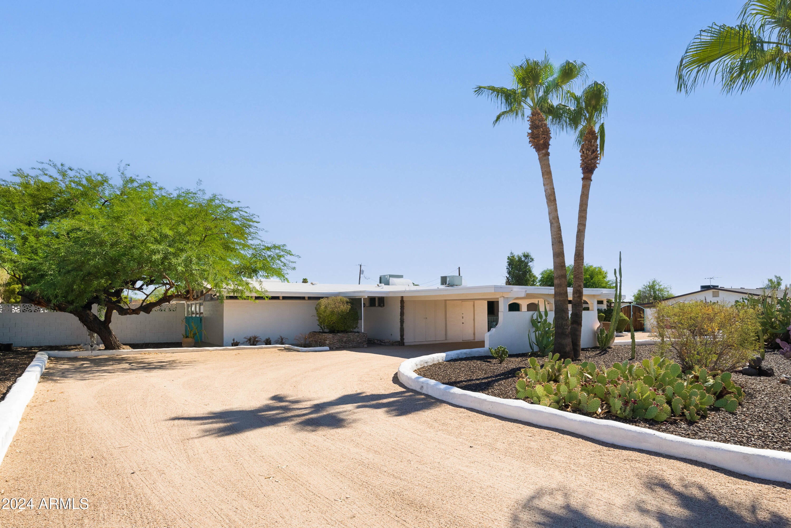 Phoenix Home & Garden Cover Home July 2022! This beautifully restored mid-century modern gem is so special and unique, you don't want to miss it! The main living room features original exposed beamed ceilings, gorgeous stacked stone fireplace, floor to ceiling & clerestory windows and opens to the new vibrant custom kitchen and dining space. Handmade Moroccan tiles adorn the kitchen backsplash with custom glass shelving and eco-friendly terrazzo countertops add a timeless appeal. In addition to the great room, there is an oversized bonus/game room with stone faced fireplace and vaulted exposed beams. Rounding out this 3 bedroom home is a bonus office/den space. All of this, plus located on a 32,000+ square foot lot with horse privileges in the heart of Scottsdale!