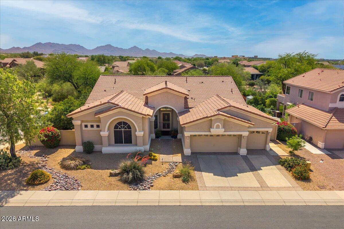 A rare find in the Desert Ridge area! This single level home sits on an oversized corner lot with only one next door neighbor & a natural desert wash behind, making it THE BEST lot in the highly desirable Sierra Pass neighborhood. As you enter the home, soaring 12  ft ceilings & expansive windows draw your eyes to the backyard oasis & the lush desert vegetation beyond the view fence. A custom-built media center is the focal point of the cozy family room with beautiful hardwood flooring that flows to the gourmet kitchen & breakfast nook. The remodeled kitchen features custom cabinetry with pull-out shelving, granite countertops & upgraded appliances including a 5-burner gas cooktop. The large primary suite offers ample space for a sitting area, a walk-in closet with California Closets custom built-ins & a beautifully remodeled bathroom with a new oversized bathtub, enlarged roll-in shower & quartz countertops. An office/library with custom-built cabinets, desk & shelving is a book lover's dream!  The guest wing includes 2 secondary bedrooms that share a jack & jill bath plus a 3rd full bathroom. A powder room is conveniently located off the main living area & a large laundry room with extra storage cabinets leads to the 3-car garage with electric vehicle charger & attached cabinets. The outdoor living space features a sparkling Pebble Sheen saltwater pool & spa enhanced by a retractable awning that provides shade beyond the large covered patio. Mature landscaping, including 4 citrus trees (Arizona sweet orange, tangelo, lemon & grapefruit), affords privacy, serenity & the occasional visit by an intrepid roadrunner!  Lovingly maintained & upgraded over the years with a new roof, new heating & cooling systems, new hot water heater & more, this home is a must see! Conveniently located just minutes from shopping, dining & entertainment at Desert Ridge Marketplace & High Street, Wildfire Golf Club, Mayo Clinic Hospital, A-rated Desert Trails Elementary School, parks, trails & easy access to Loop 101 & SR 51 freeways.