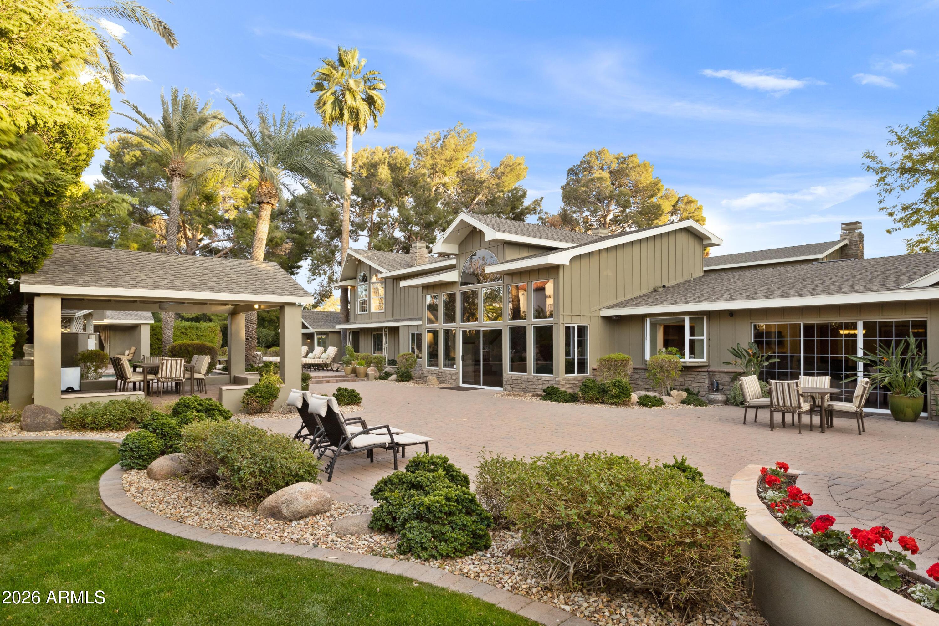 $150,000 price enhancement! With over $1 million invested in upgrades, this private one-acre Craftsman estate blends timeless character with modern luxury while capturing breathtaking views of Camelback Mountain. Privately gated at the end of a quiet cul-de-sac and free of obstructing power lines, the property offers exceptional privacy, serenity, and picturesque desert scenery.
The main residence features 4 spacious bedrooms and 4.5 bathrooms, highlighted by soaring vaulted ceilings and thoughtfully designed living spaces. A luxurious primary suite serves as a private retreat, complete with a tranquil sitting area, balcony with mountain views, an expansive walk-in closet, dual vanities, dual water closets, and a dedicated fitness room for ultimate convenience. Designed for both comfort and entertainment, the home includes a lounge /game room, state-of-the-art theater and a dedicated executive office, ideal for working from home. Two separate casitas: 1 bedroom, 1 bathroom casita with a kitchenette/great room and a 1 bedroom,  1.5 bathroom with laundry, full kitchen and great room provide the perfect accommodations for guests, extended family, or private studios.  Outdoor living is equally extraordinary. Lush, mature landscaping surrounds the property, creating a resort-style setting with a garden, heated pool, putting green, children's playground, and a peaceful Zen/Yoga deck--perfect for relaxation and wellness.  A beautifully crafted ramada with a fully equipped outdoor kitchen, generous dining area, and a mounted television creates the perfect setting for hosting gatherings, enjoying al fresco meals, or watching the big game under the Arizona sky.
Just steps away, a grand outdoor fireplace provides warmth and ambiance, inviting guests to relax long after sunset. From this serene vantage point, enjoy breathtaking views as the evening light casts a golden glow across Camelback Mountain--an unforgettable backdrop for Arizona's legendary sunsets.  Car enthusiasts and collectors will appreciate the remarkable 12-car garage, offering ample space for vehicles, hobbies, and storage.
Combining rare acreage, iconic mountain views, and an unmatched collection of amenities, this Arcadia Craftsman estate presents a truly exceptional opportunity to experience refined desert living.